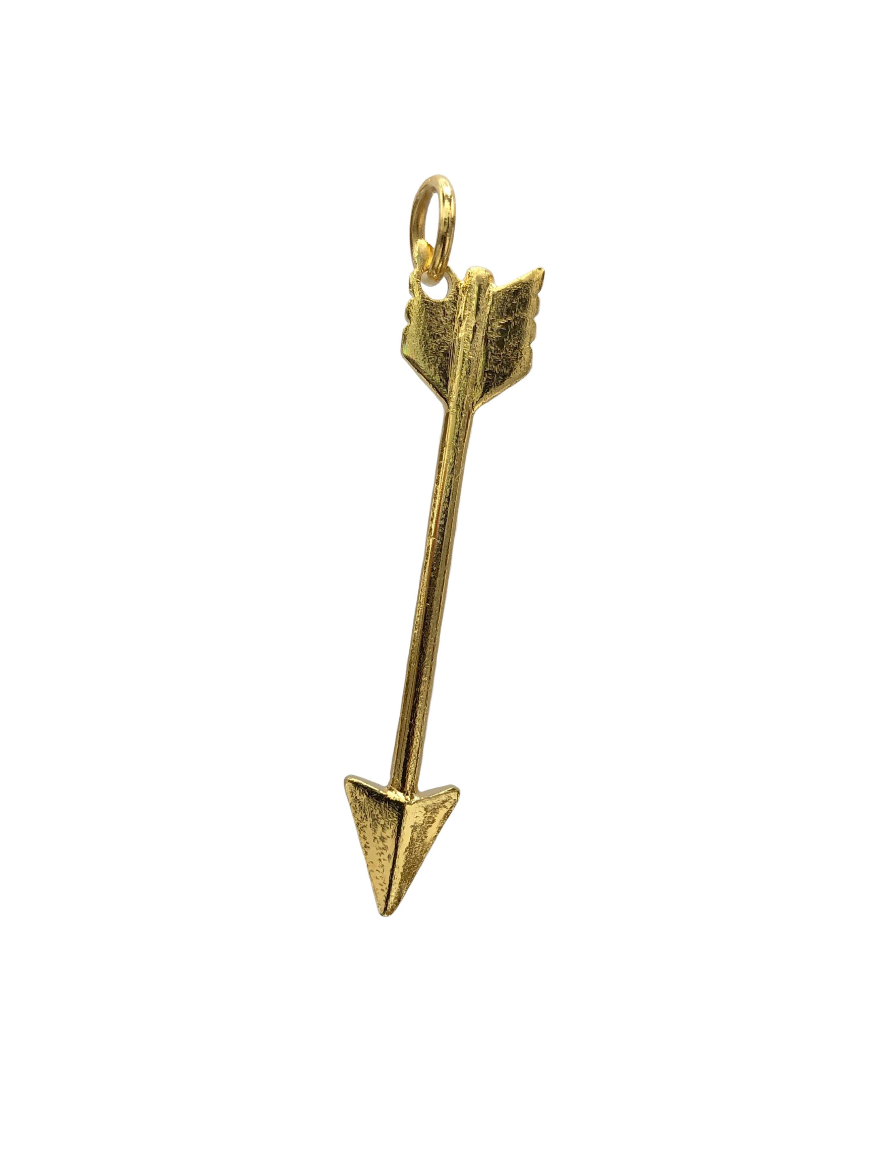 Gold arrow-shaped pendant with a loop for attaching to a chain. It features detailed fletching at one end and a pointed arrowhead at the other, displayed against a white background.