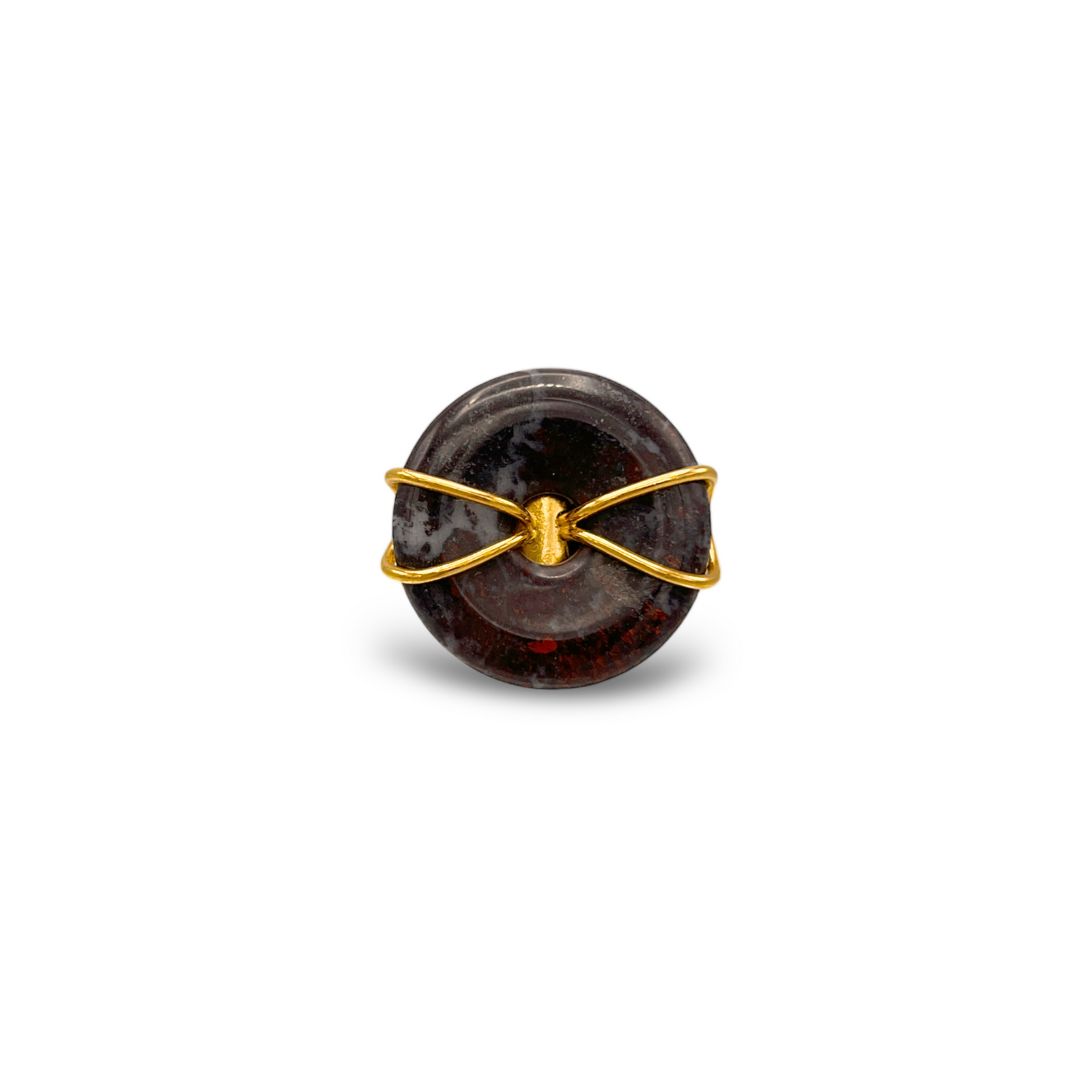 The Gold Cornelia Ring by JAREDJAMIN Jewelry Online features a glossy, round dark jasper bead wrapped in an 18K gold plated wire "X" pattern, creating a minimalistic adjustable statement piece against a plain white background.