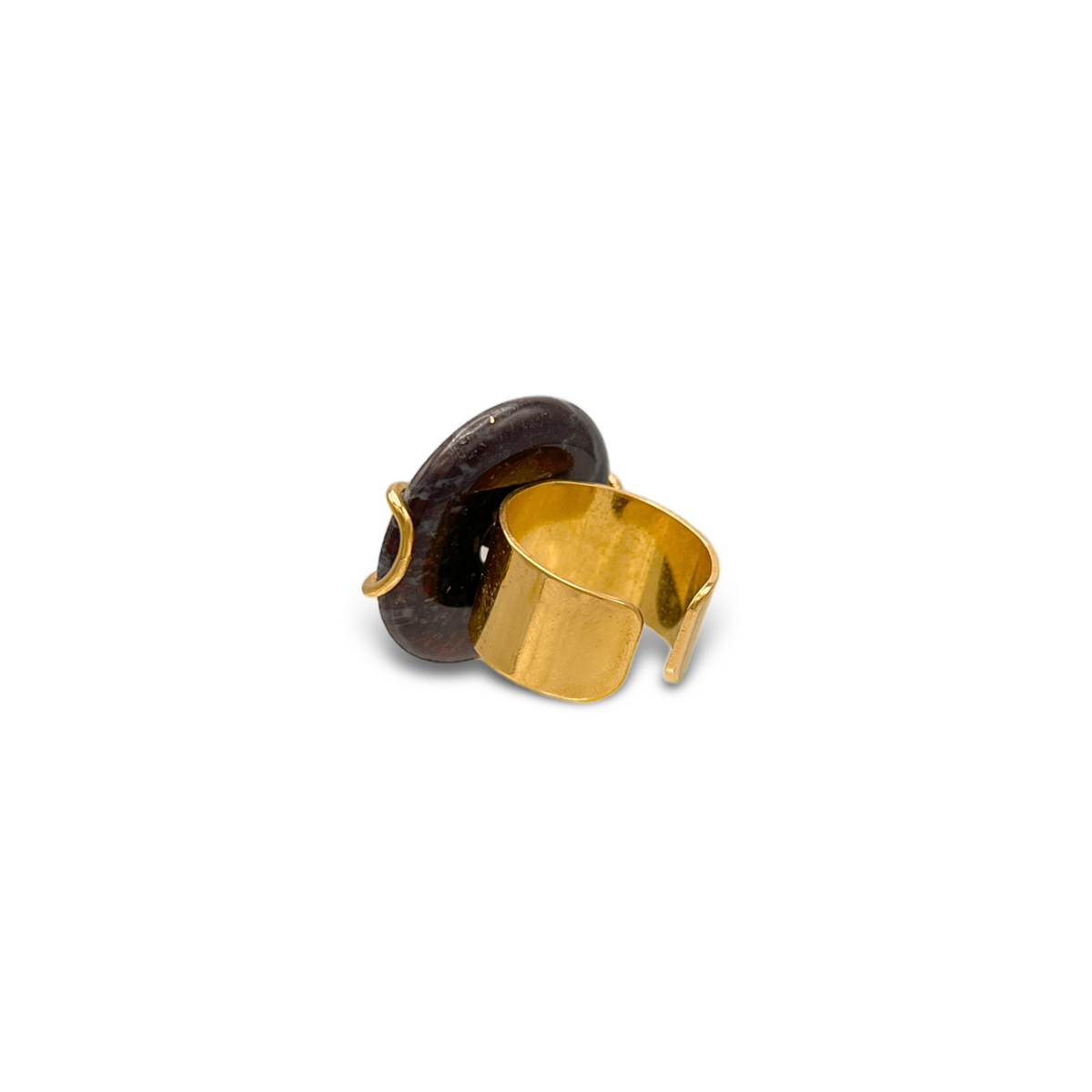 The Gold Cornelia Ring by JAREDJAMIN Jewelry Online features an 18K gold plated adjustable band and a round, dark brown jasper stone. The ring is displayed at an angle on a white background, showcasing its glossy finish and elegant design.