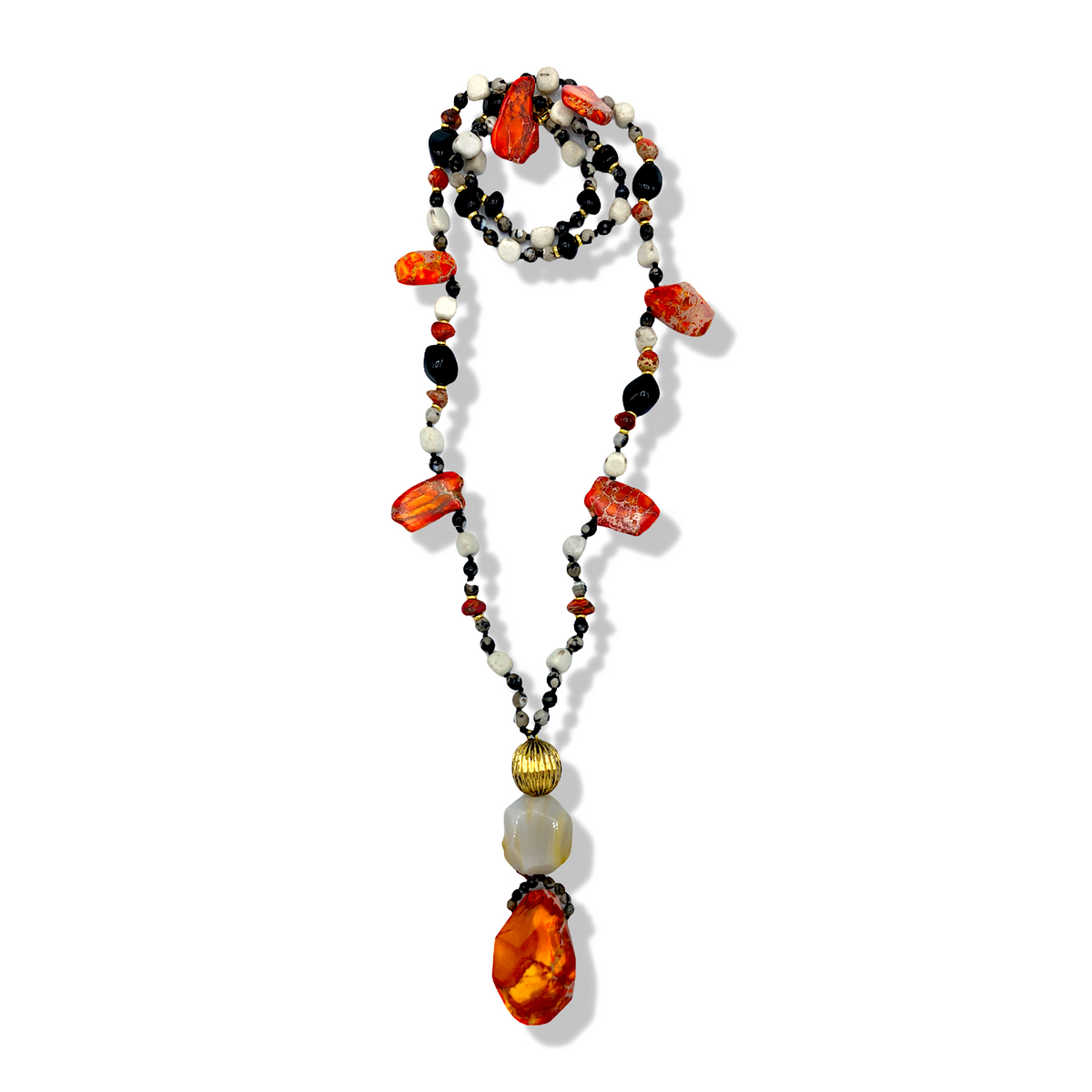 JAREDJAMIN Firestarter ネックレス is hand-knottedとホワイト, ブラック,とorange beads, チャンキー orange stones,とJasper accents. A dramatic ペンダント combines a large ゴールド bead, opalescent bead,と大胆な orange stone. Shown coiled の上の 白い背景.