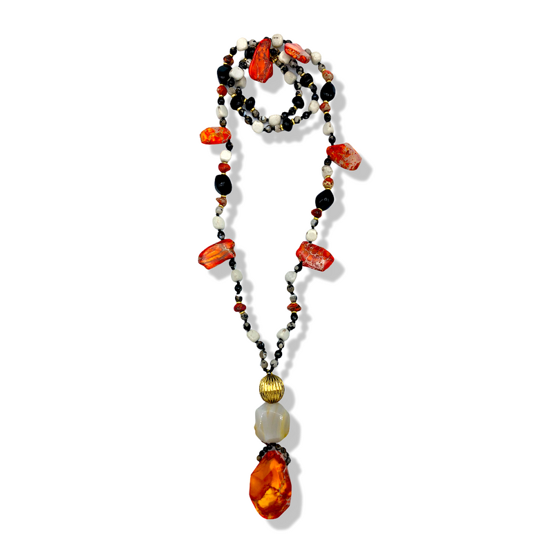 Les JAREDJAMIN Firestarter collier is hand-knotted avec white, black, et orange beads, chunky orange stones, et Jasper accents. Un dramatic pendentif combines a large or bead, opalescent bead, et audacieux orange stone. Shown coiled sur un fond blanc.