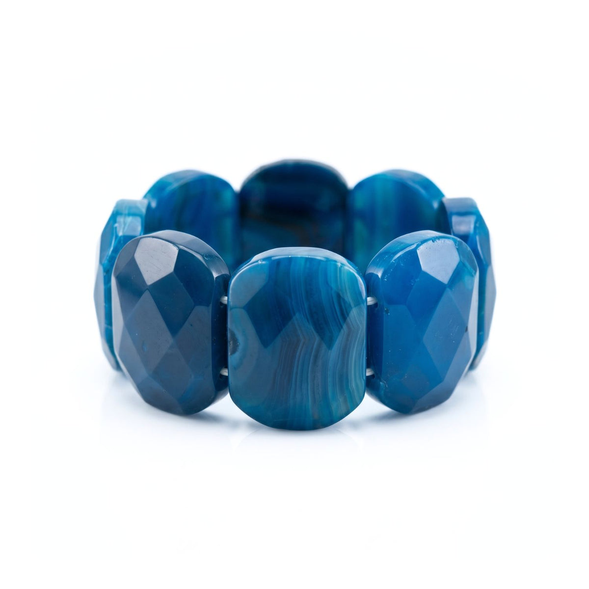 High-resolution studio product shot of the JAREDJAMIN Calypso Blue Agate Chunky Bracelet resting upright on a white background, highlighting the wide, faceted oval-rectangular stone segments and deep blue natural color banding.