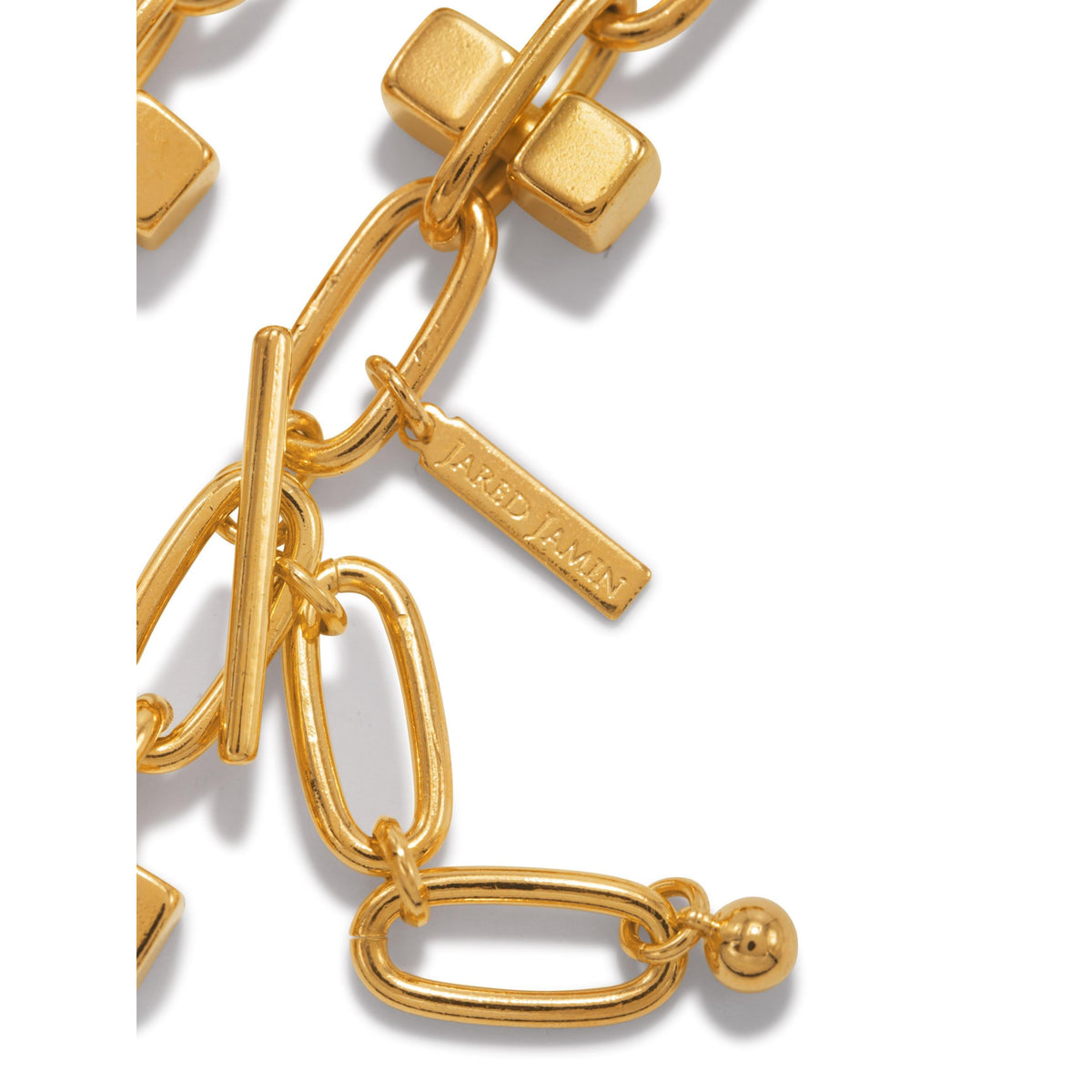 Close-up of the Blockbuster Gold Chain Collier Necklace by JAREDJAMIN Jewelry Online, featuring 18K gold-plated large oval and rectangular links, cube beads, toggle clasp, and a signature engraved charm gleaming on white.