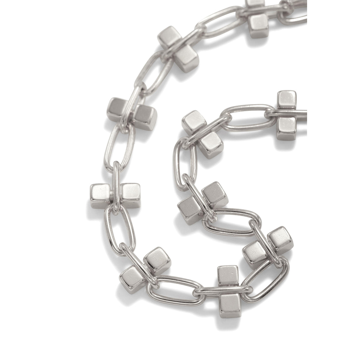 A close-up of the Blockbuster Silver Chain Bracelet by JAREDJAMIN Jewelry Online, featuring silver-toned rectangular links and cross accents, arranged in a loose spiral with a toggle clasp on a plain white background.