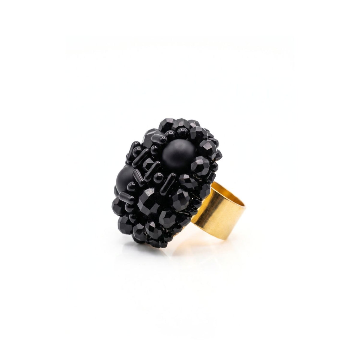 Side view of the black glass bead cocktail ring, showing the cluster's height above the adjustable gold-plated band.