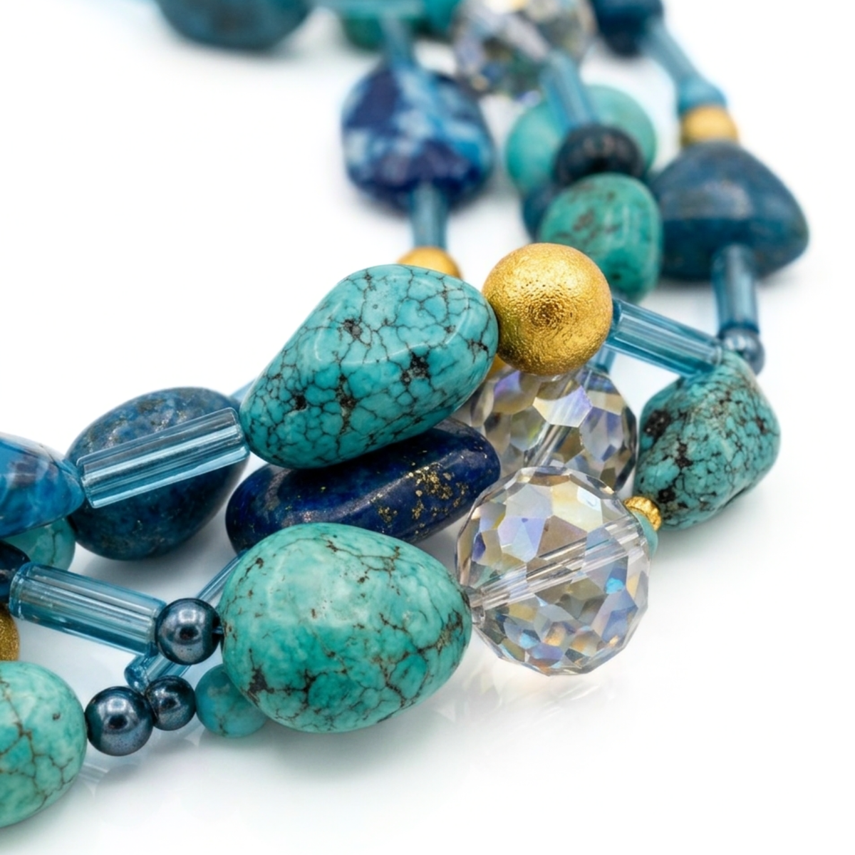 Close-up studio macro shot focusing on the textured 18k gold stardust beads, faceted crystals, and polished turquoise stones of the Blue Reef multi-strand necklace.