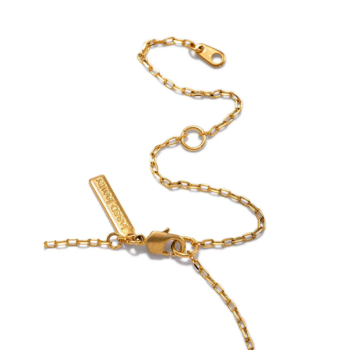 A close-up of the Lindy Circles Pendant Chain Necklace by JAREDJAMIN Jewelry Online, featuring delicate rectangular links, a lobster clasp, round jump ring, and a rectangular “JAREDJAMIN” tag; the chain rests slightly coiled on a white surface.