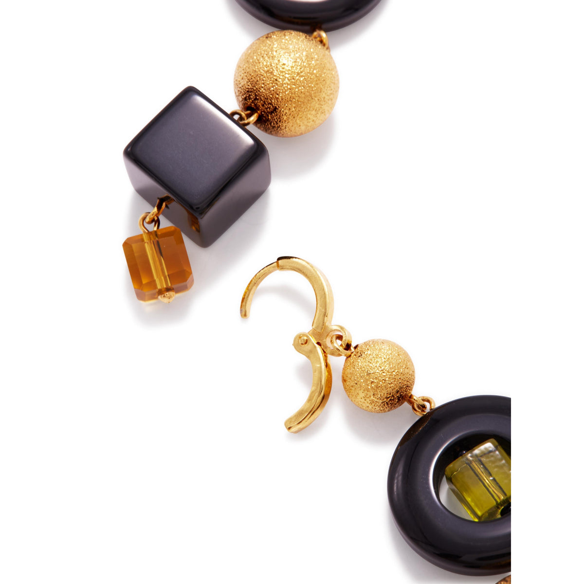 Un primer plano of JAREDJAMIN Joyería Online’s Cubism Leverback colgante pendientes, showcasing a modern oro-toned design con geometric glass beads—black round, texturizado oro sphere, glossy black cube, amber cube, y yellow gem—in a black anillo.