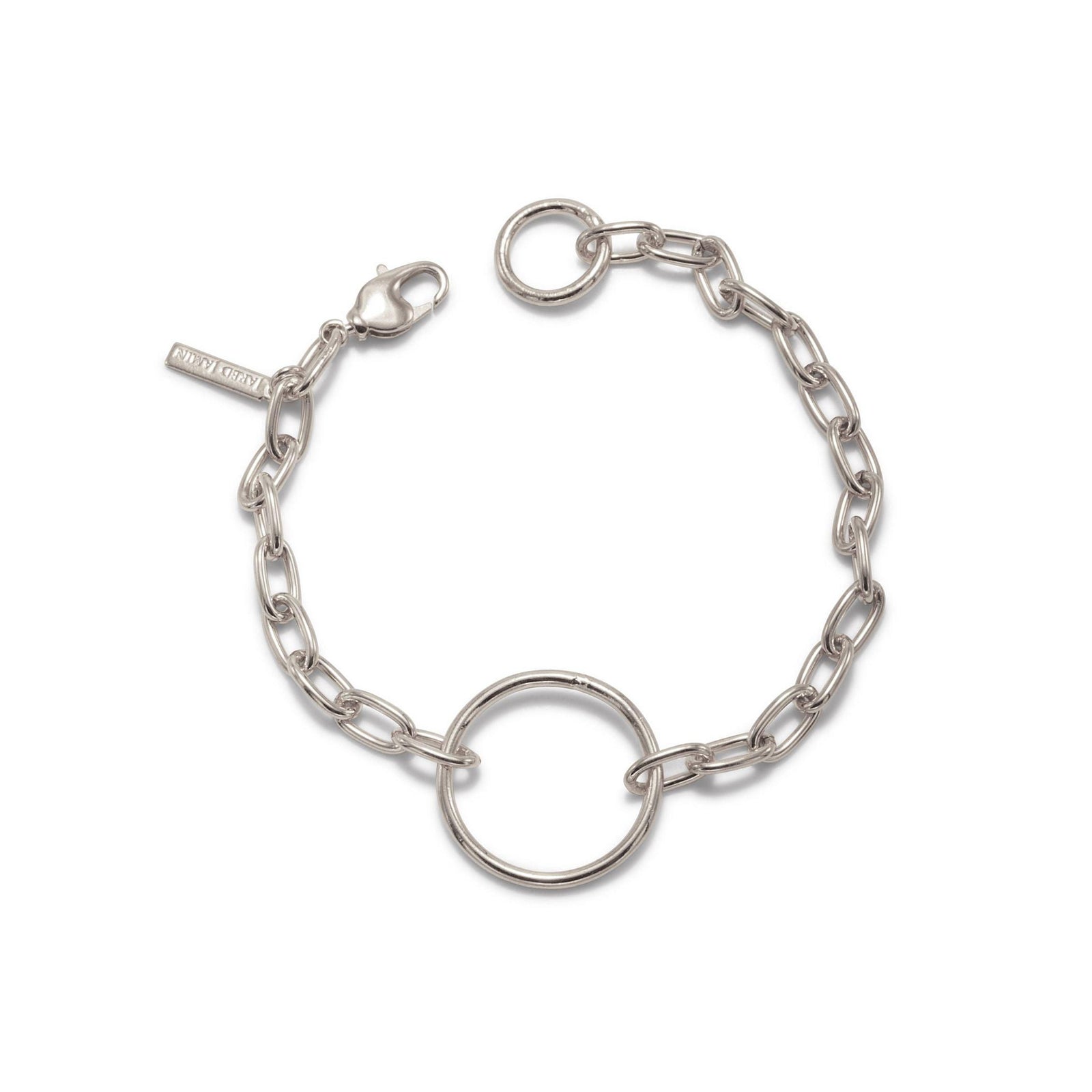 The Silver Chain Reaction Ellipse Bracelet by JAREDJAMIN Jewelry Online features elongated oval links, a central circular ring, lobster clasp closure, and a minimalist rectangular tag for a modern touch. Part of the Chain Reaction Collection.