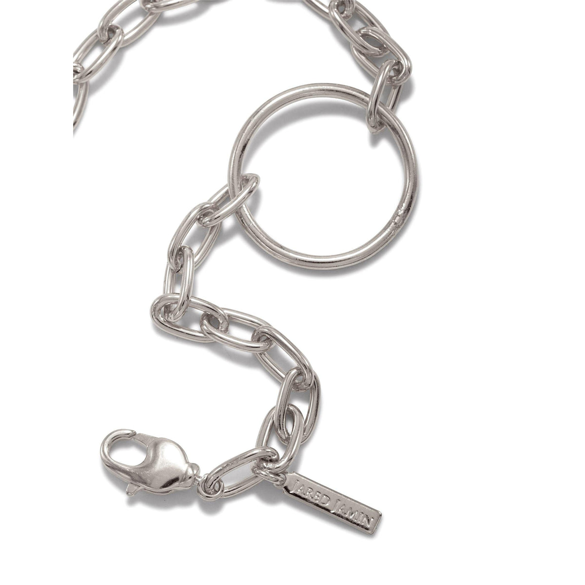 A close-up of the Silver Chain Reaction Ellipse Bracelet by JAREDJAMIN Jewelry Online, with large oval links, a central ring, lobster clasp, and tag detail, photographed on a white background.