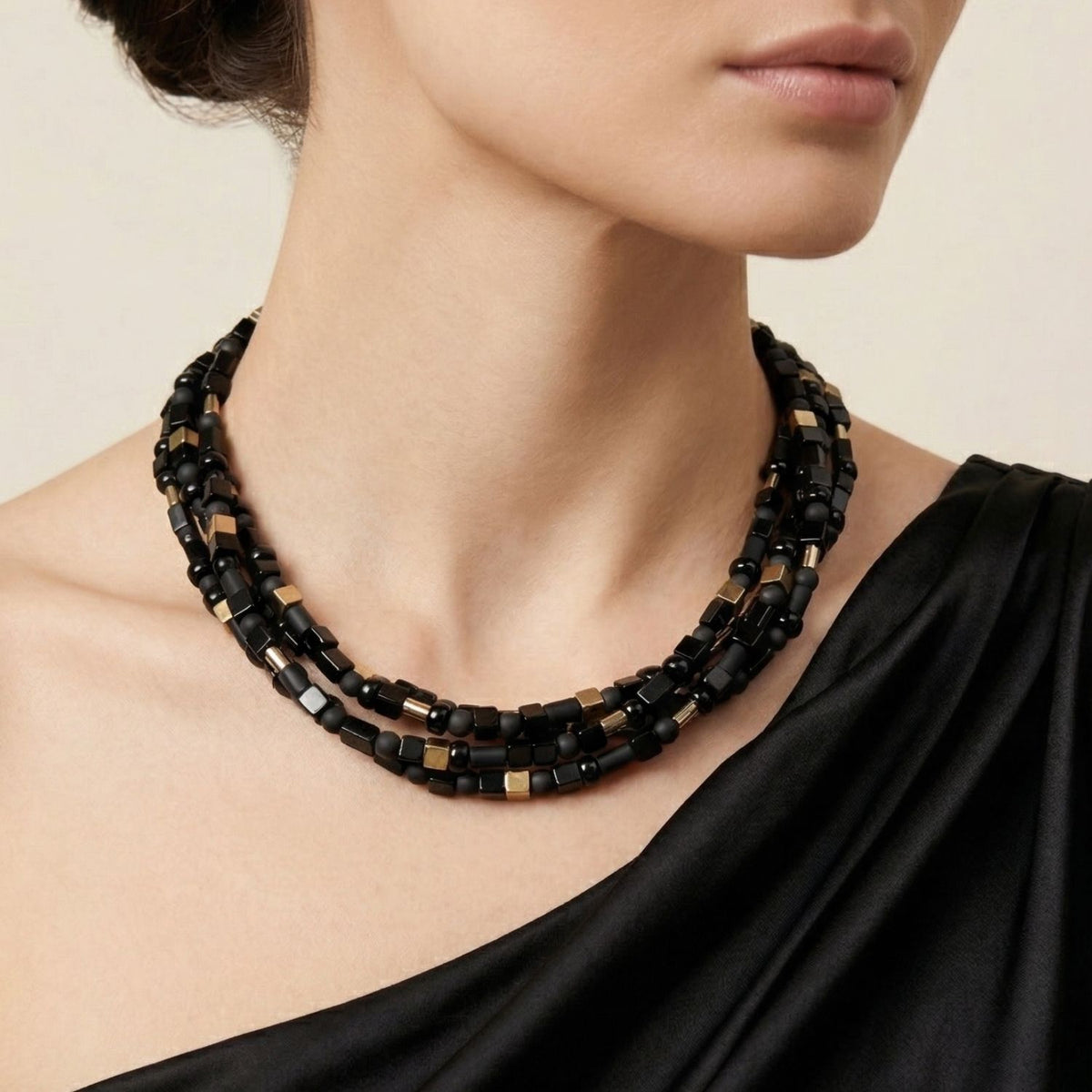 Model wearing the Corrinne necklace — multiple strands of black onyx beads layered at the neckline.