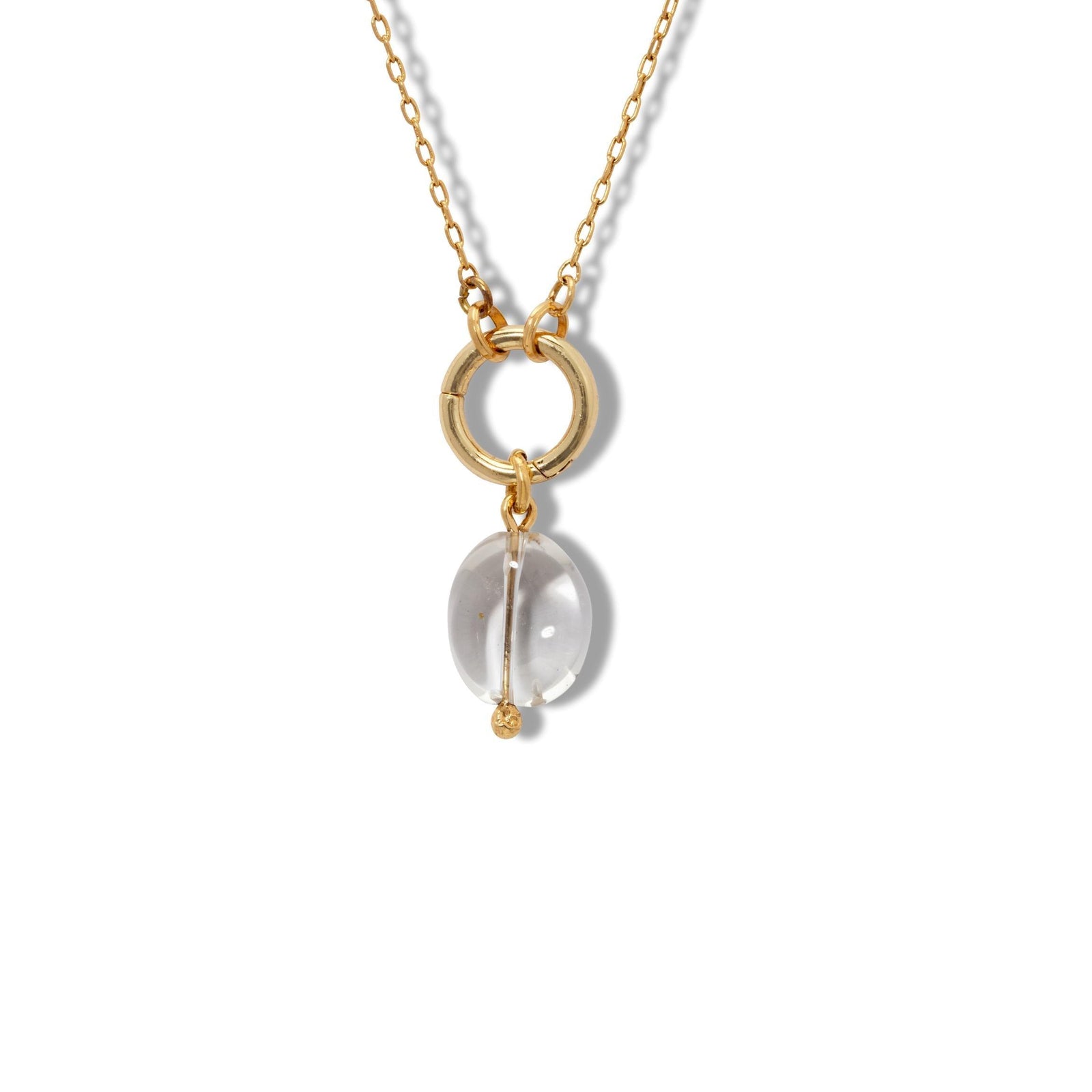 The Crystal Quartz Pebble Necklace Pendant Charm by JAREDJAMIN Jewelry Online features two interlocking gold rings, a clear crystal quartz accent, and a dangling gold bar—perfect for fans of healing jewelry. Set against a plain white background.