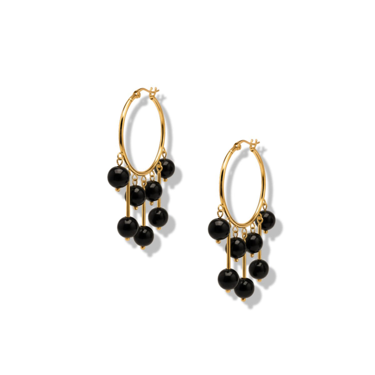 Les Daniela Dangle Onyx boucles d'oreilles par JAREDJAMIN Bijoux en Ligne présentent plaqué or créoles avec five cascading black poli stone beads each. montré sur a fond blanc avec soft shadows.