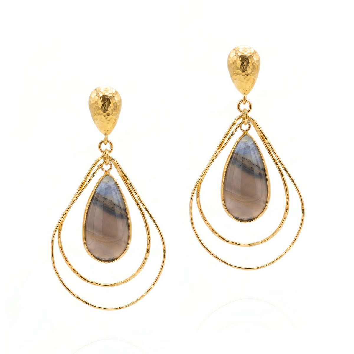 High-resolution studio product shot of the JAREDJAMIN Darlena Drop Earrings against a white backdrop, highlighting the hammered 18k gold-plated post tops, nested wire teardrop loops, and the polished grey and blue natural banded agate pendants.