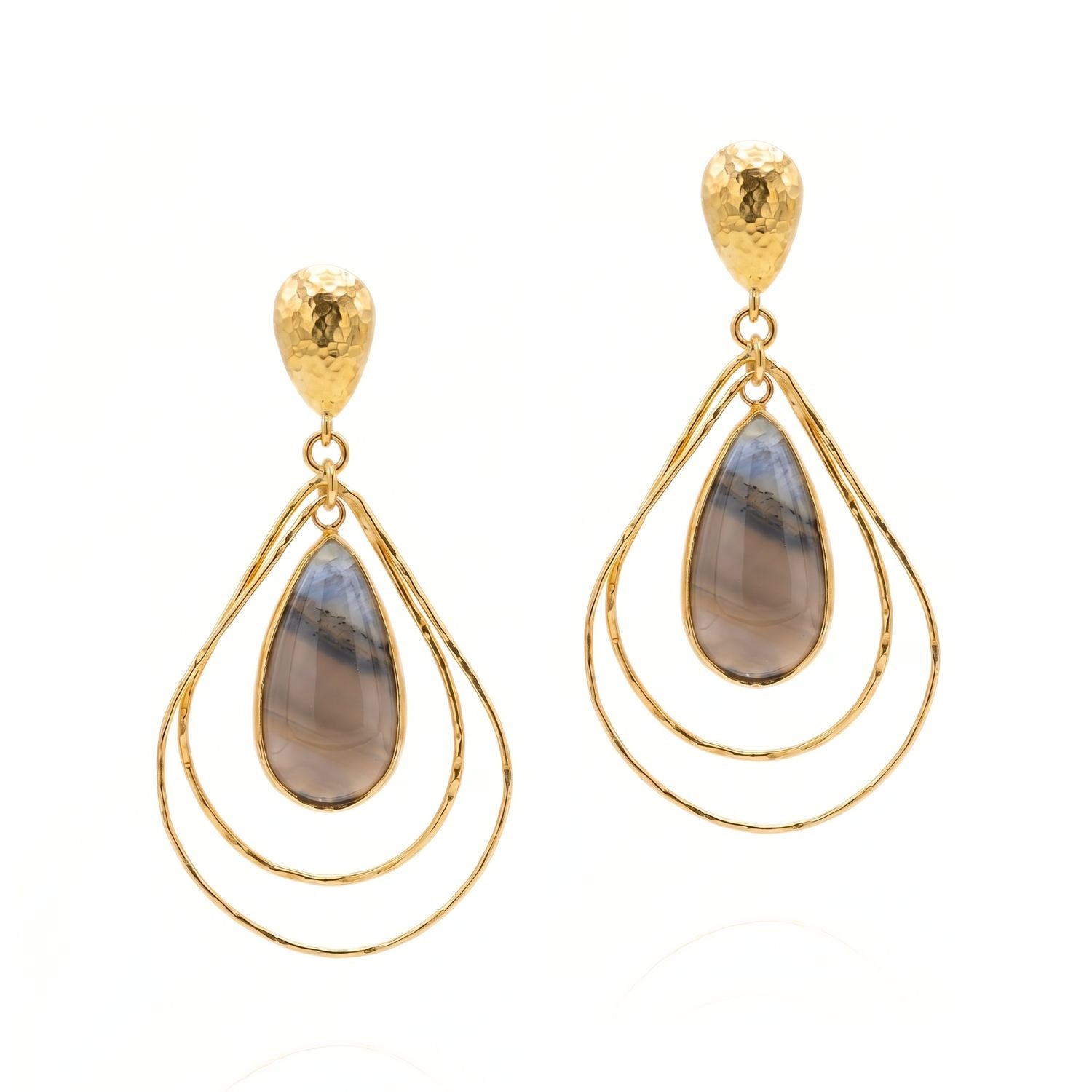 High-resolution studio product shot of the JAREDJAMIN Darlena Drop Earrings against a white backdrop, highlighting the hammered 18k gold-plated post tops, nested wire teardrop loops, and the polished grey and blue natural banded agate pendants.