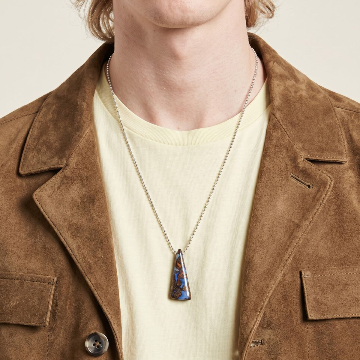 From chin to collarbone, a tan suede jacket and cream tee frame the Down Under Boulder Opal Necklace—a blue-brown opal, hand-set in West Hollywood. Crafted in eco-conscious, small batches. Style Note: punctuates basics or silk evening layers alike.