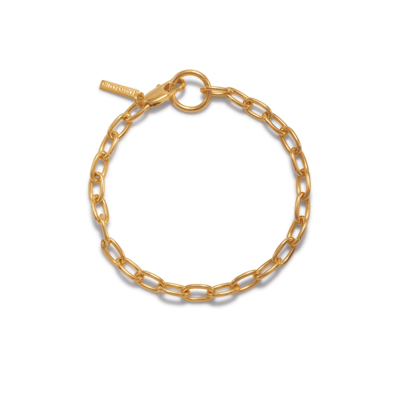 The Gold Chain Reaction Bracelet by JAREDJAMIN Jewelry Online features elongated oval links, a round clasp, and a rectangular engraved tag. Crafted in 18K gold-plated metal, it’s scratch and tarnish resistant.