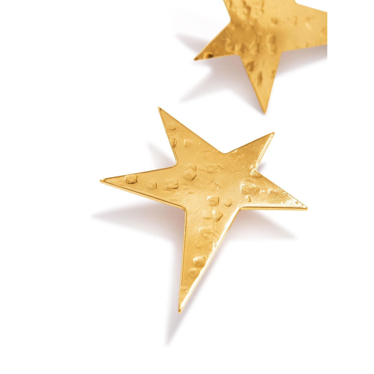 Two Gold Shooting Star Stud Post Earrings by JAREDJAMIN Jewelry Online, crafted in hammered 18K gold plate, rest on a white background—one fully visible and the other partially shown—with soft shadows beneath them.