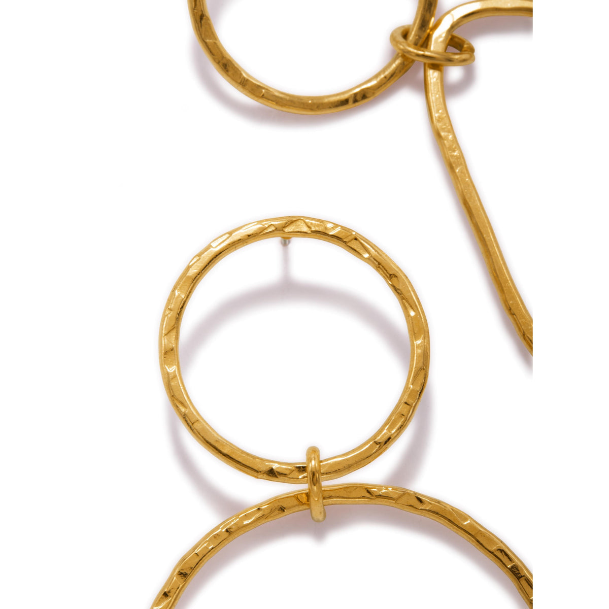 gros plan of JAREDJAMIN Bijoux en Ligne’s or texturé Tear Post boucles d'oreilles. Les hammered 18K or finish et geometric design stand out against a plain fond blanc, showcasing the shine et detail of these élégant boucles d'oreilles.
