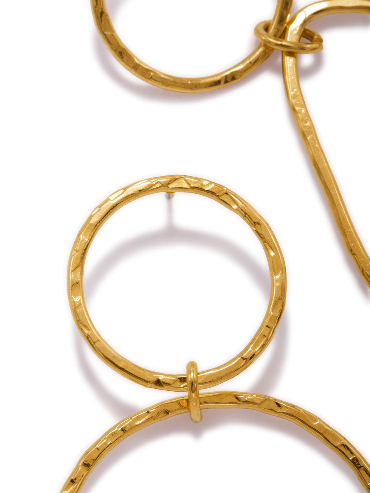 A close-up of a gold chain with interlocking circular links featuring a hammered texture similar to the warm sheen of 18K Gold Textured Tear Post Earrings by JAREDJAMIN Jewelry Online. One prominent circle takes center stage against a plain white background.