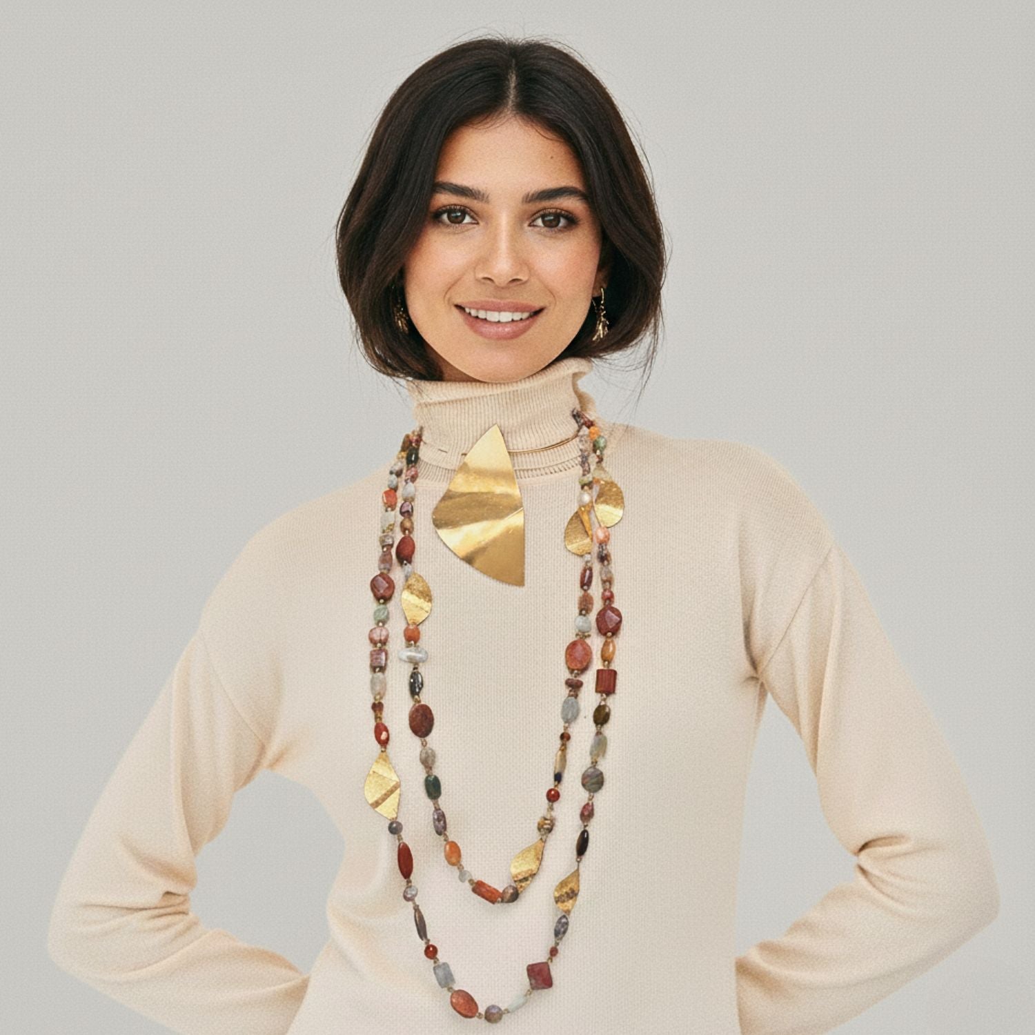 The Geo Twist Gemstone Linked Necklace by JAREDJAMIN Jewelry Online showcases earthy jasper stones in brown, amber, cream, and gray with textured 18K gold-plated charms for a layered artisanal look on a white background.