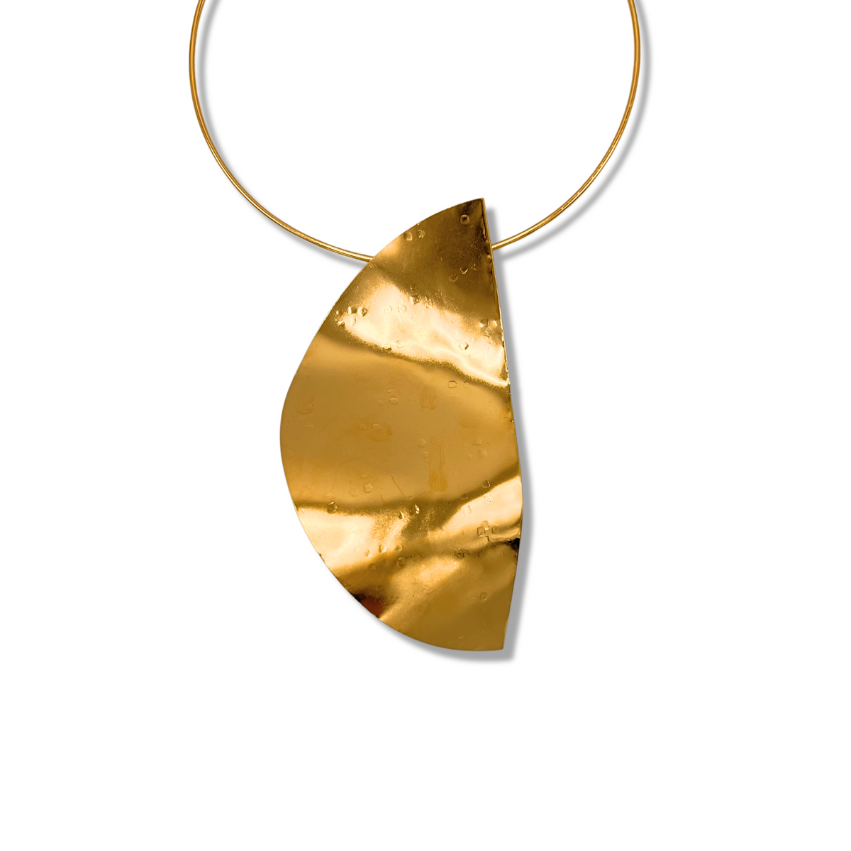 The JAREDJAMIN Jewelry Online Geo Twist Pendant Neck Wire features a large, asymmetrical hammered 18K gold plated half-oval pendant on a slim circular neck wire, shown against a plain white background.