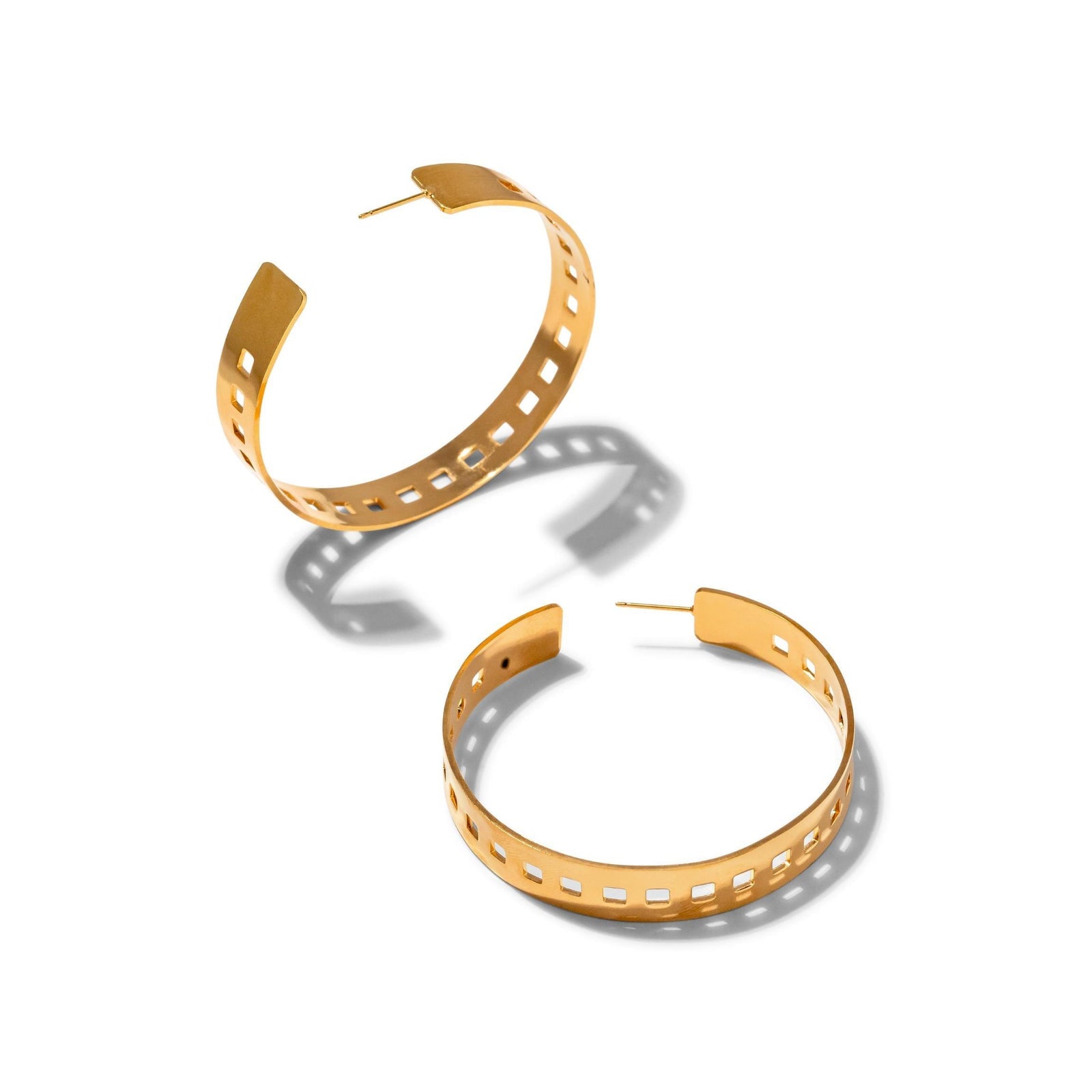 The 'Girls On Film' Hoop Post Earrings by JAREDJAMIN Jewelry Online feature a modern geometric design with square cutouts and a shiny gold finish, inspired by classic Hollywood style. Displayed on a white background with soft shadows.