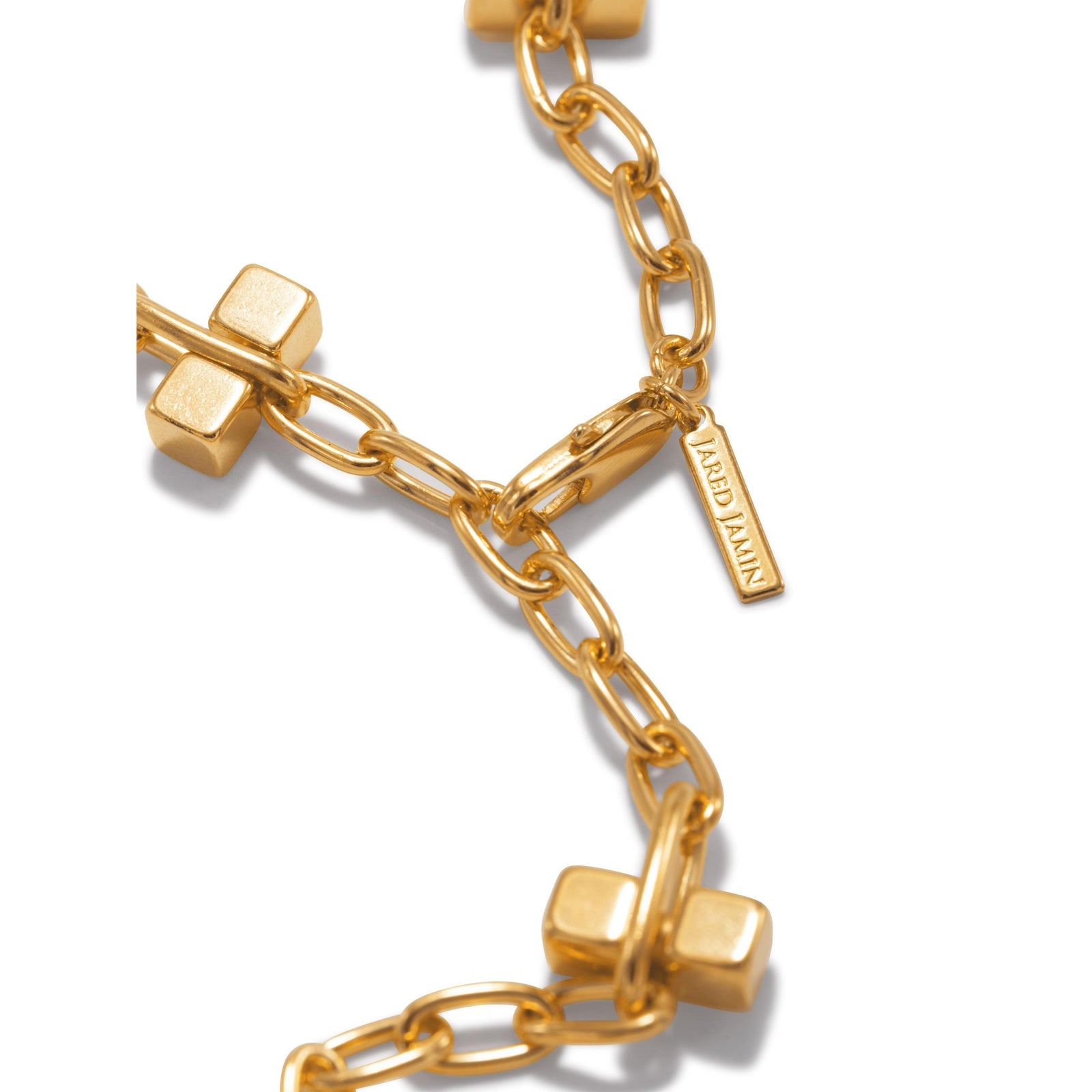 The Gold Blockbuster Lite Choker Necklace by JAREDJAMIN Jewelry Online features elongated oval links with flat, square charms. Crafted from 18K gold plated brass with a lobster clasp, this modern necklace is shown against a white background.