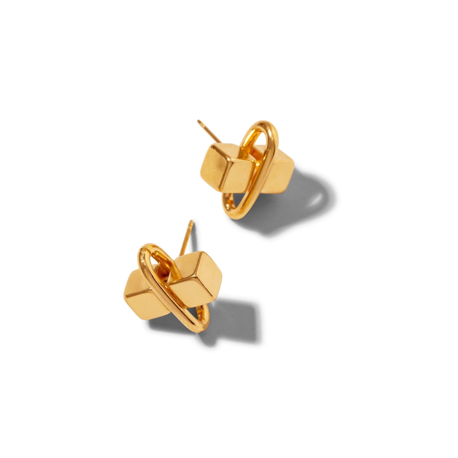 The Gold Blockbuster Stud Post Earrings by JAREDJAMIN Jewelry Online feature a geometric 18K gold-plated brass design with a cube and circular ring, displayed on a white background. These modern link earrings suit any occasion.