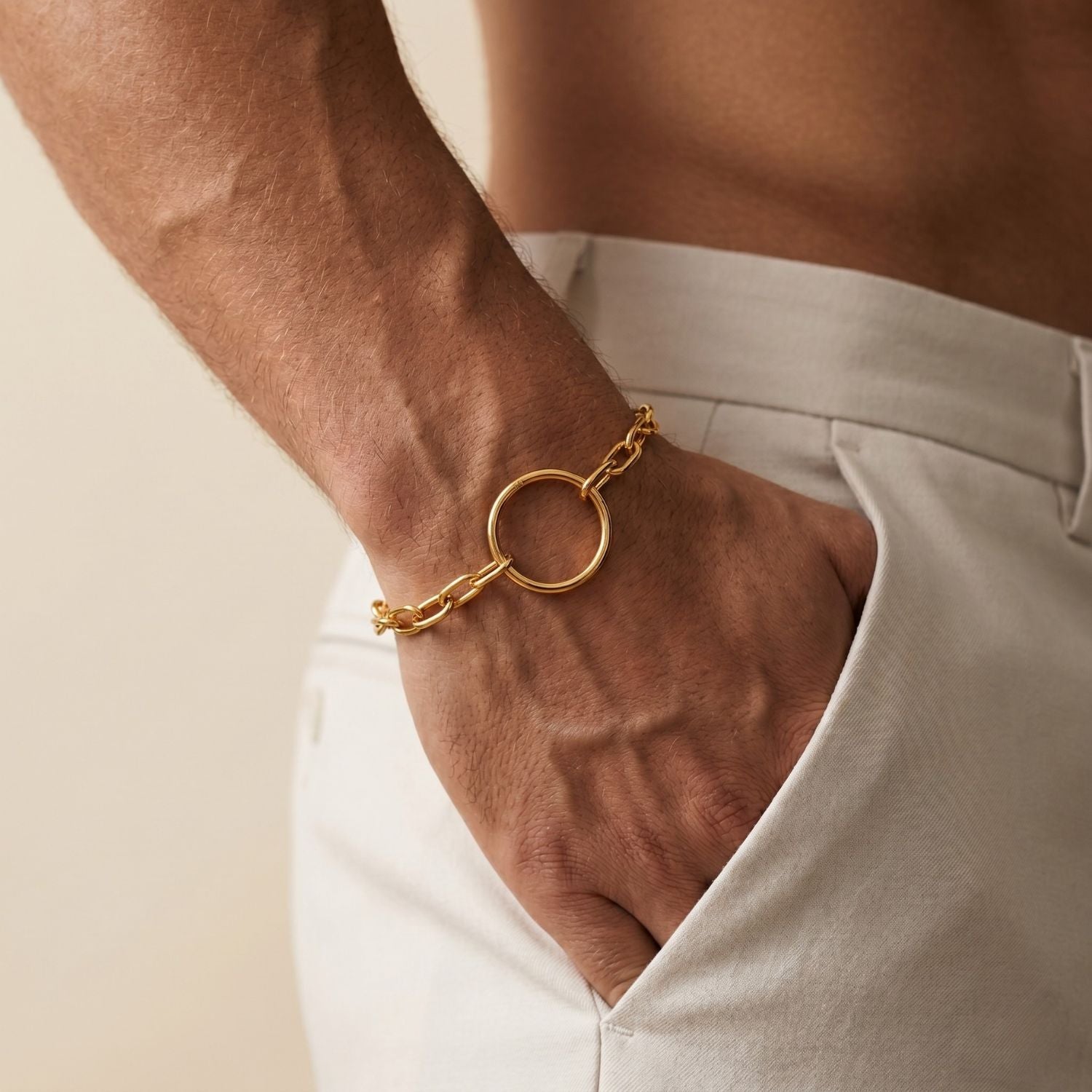 The Gold Chain Reaction Ellipse Bracelet by JAREDJAMIN Jewelry Online features elongated links, a round open ring centerpiece, 18K gold plating, lobster clasp, and "PINKCITY" tag—styled flat on a white background.