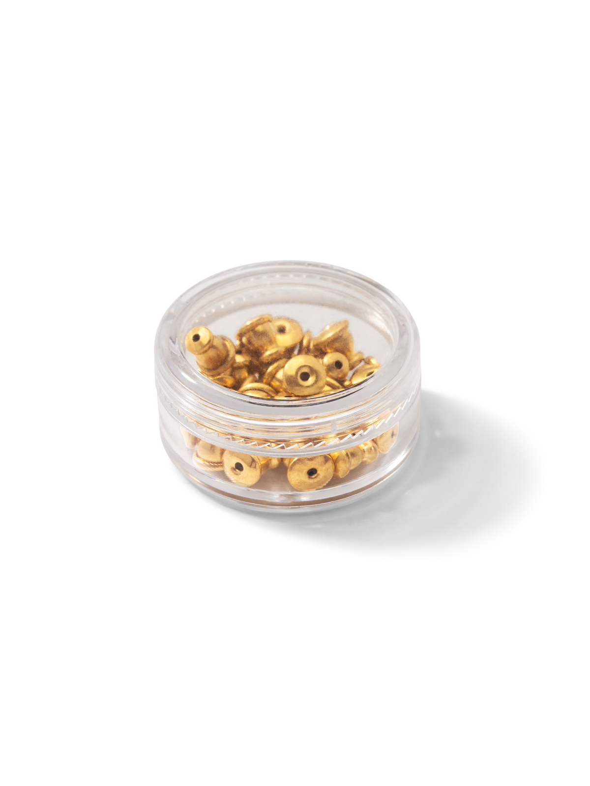 A small container from JAREDJAMIN Jewelry Online holds many gold-colored Earring Backings and some silver ones. The screw-on lid secures them, casting a shadow on the white surface.