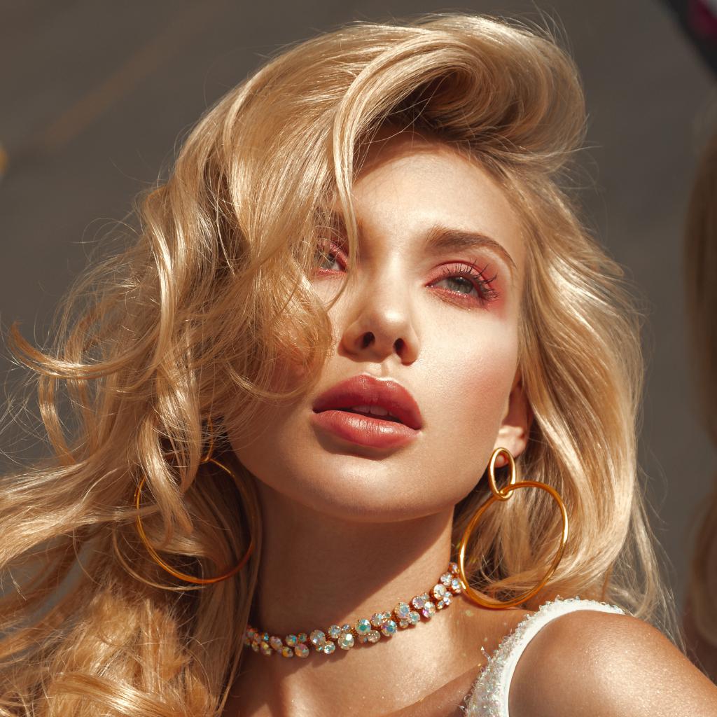 The Everly Dangle Hoop Post Earrings by JAREDJAMIN Jewelry Online feature minimalist 18K gold plated hoops with a small oval loop on a large circle, offering a sleek, modern look against a white background.