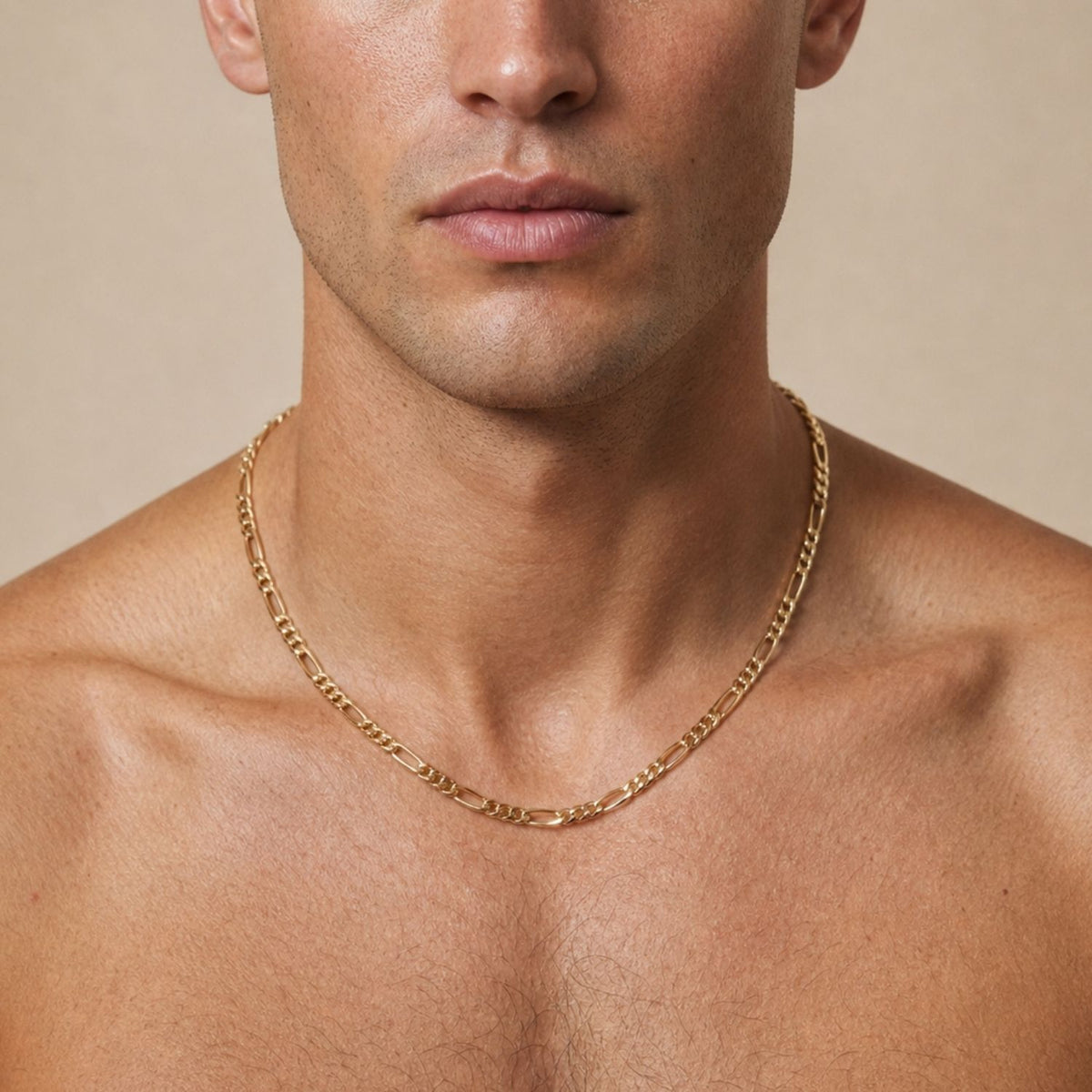 Front portrait of a male model with a bare chest, styling the 18-inch Gold Finley-Figaro Chain Necklace to demonstrate its versatile, gender-neutral appeal and perfect collarbone-grazing length.