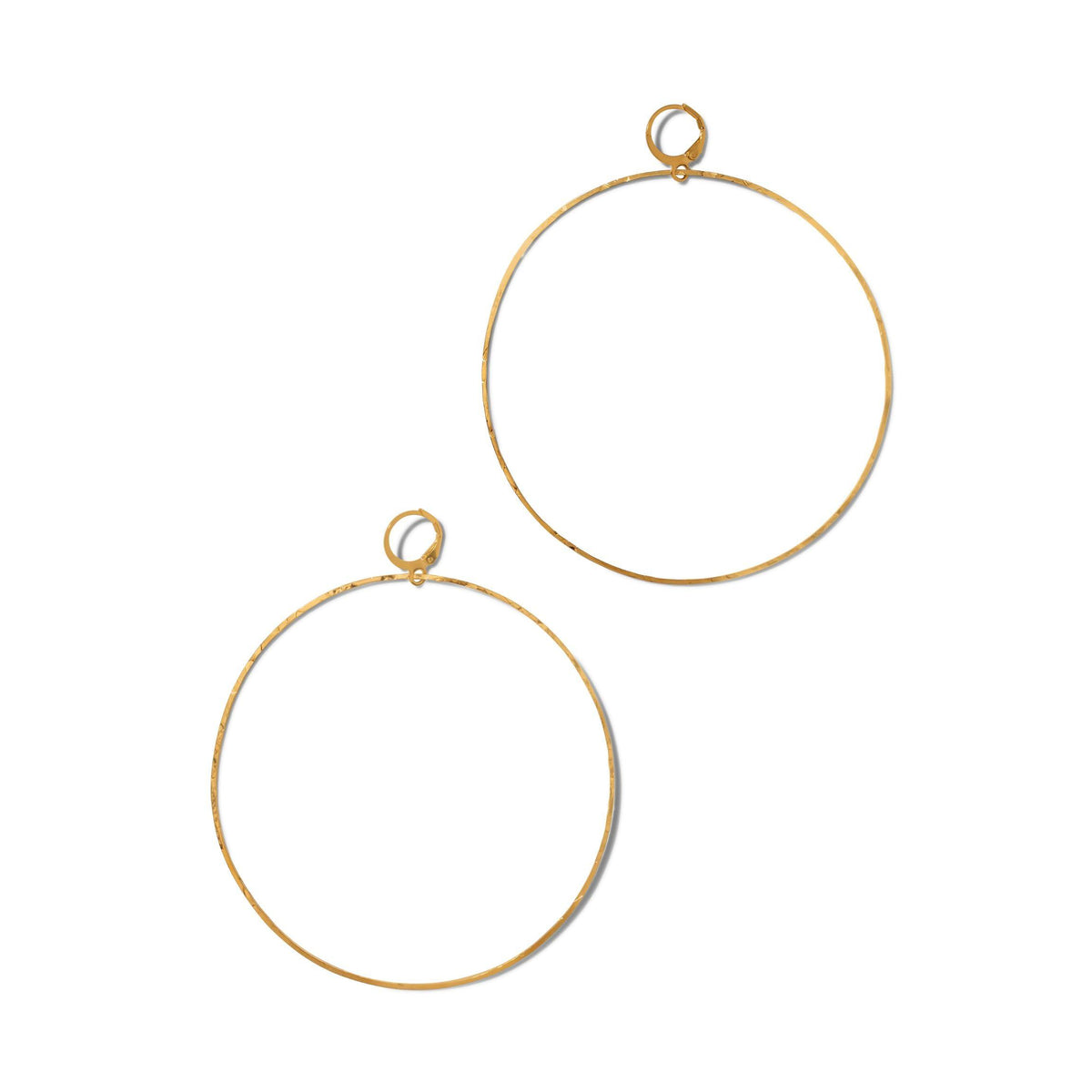 Los oro Halo texturizado aro pendientes de JAREDJAMIN Joyería Online are large, thin aros con a minimalist design y slight texture, con small circular clasps. Displayed against a plain fondo blanco, their shape is subtly irregular y unadorned.