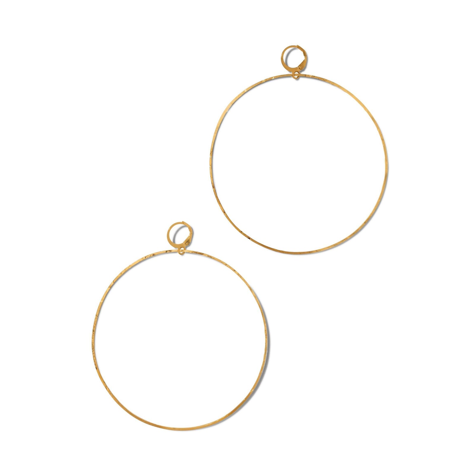 The Gold Halo Textured Hoop Earrings by JAREDJAMIN Jewelry Online are large, thin hoops with a minimalist design and slight texture, featuring small circular clasps. Displayed against a plain white background, their shape is subtly irregular and unadorned.