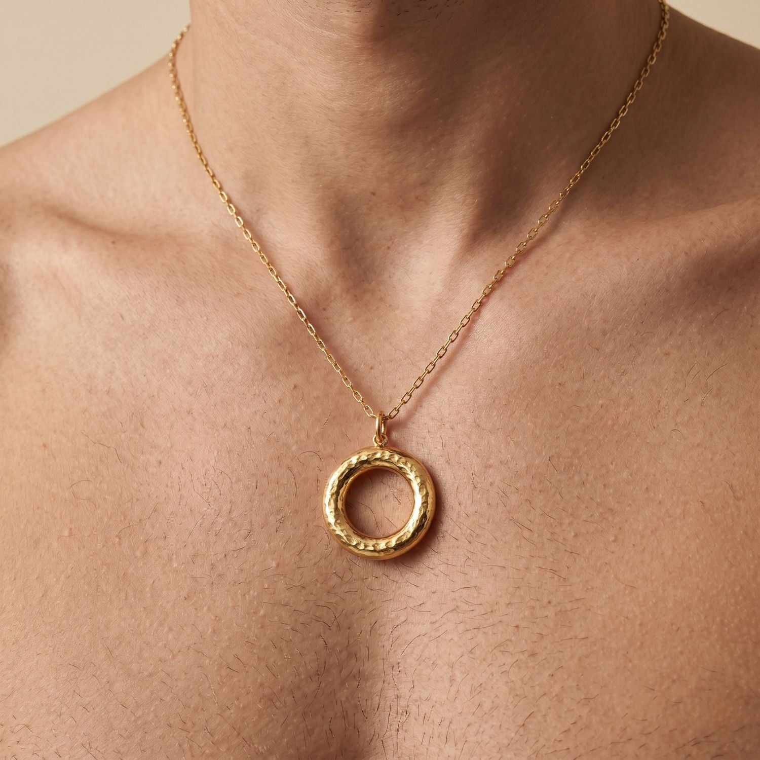 The Gold Hammered Doughnut Necklace Pendant Charm by JAREDJAMIN Jewelry Online is an 18K gold plated circular charm with a hammered finish, open center, and loop for attaching to chains. Shown on a plain white background.