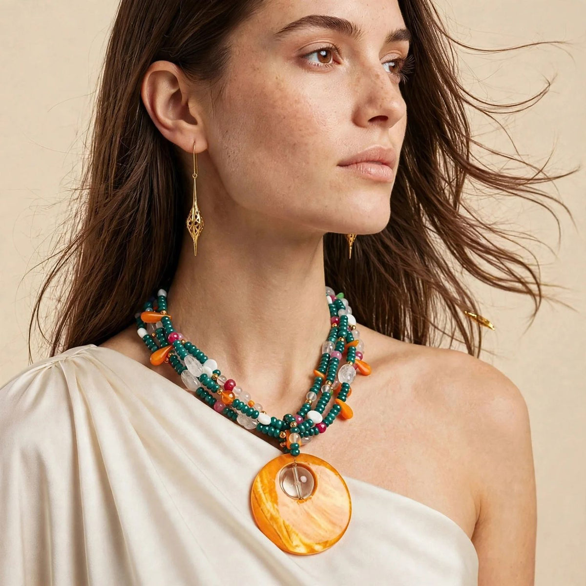 Gold Jeannie Drop Hook Earrings, model wearing the gold drop earrings, long pierced drops, with a beaded shell necklace.