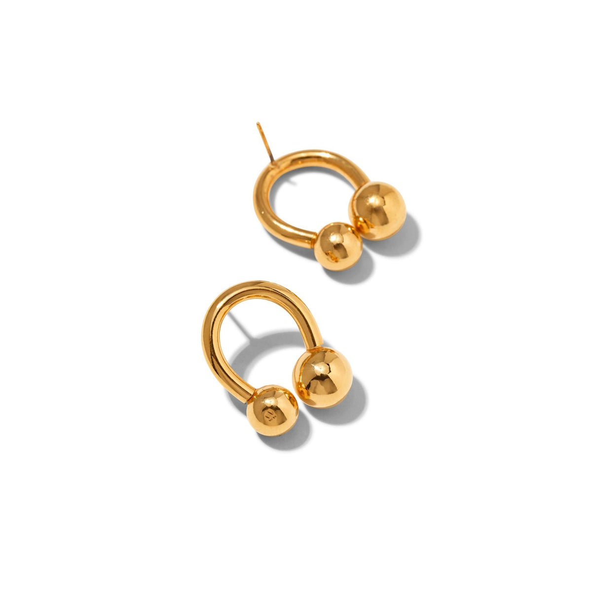 Les or Lucky Orbita Post boucles d'oreilles de JAREDJAMIN Bijoux en Ligne présentent an open horseshoe design avec 18K or plating et two poli or spheres of different sizes at each end, présenté sur a fond blanc avec soft shadows.