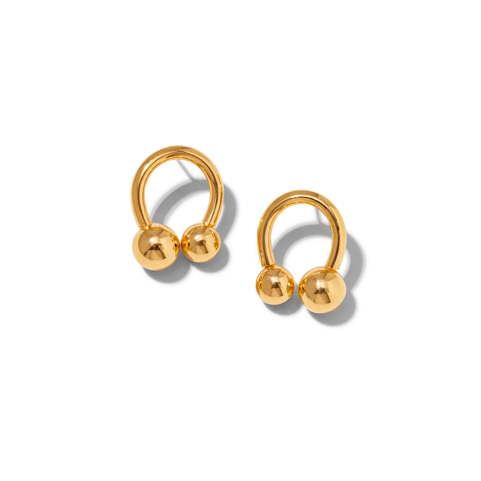 The Gold Lucky Orbita Post Earrings by JAREDJAMIN Jewelry Online feature 18K gold plating in an open horseshoe design, each adorned with two polished gold spheres. Shown on a white background with soft right shadows.
