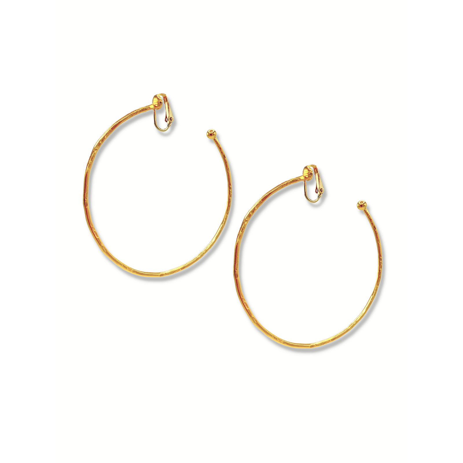 The Gold Medium Hooptastic Clip On Hoop Earrings by JAREDJAMIN Jewelry Online feature a hammered 18K gold finish, rounded ends, and hinged clasps. Arranged diagonally, they stand out against a plain white background.