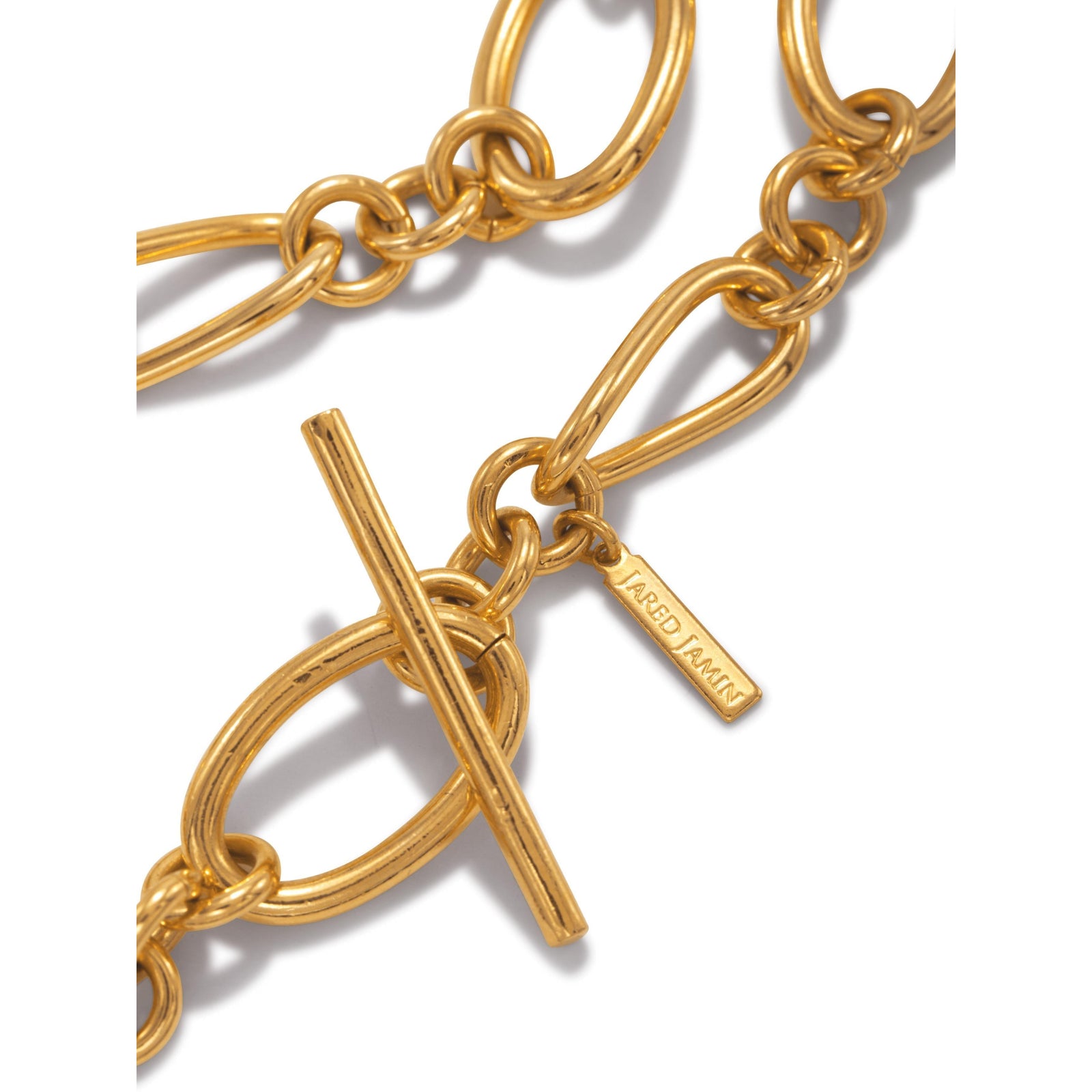 The Gold Ophelia Choker Chain Necklace by JAREDJAMIN Jewelry Online features large gold-plated brass oval links, a toggle clasp with a dangling oval link for a modern touch, and a small rectangular tag near the clasp.