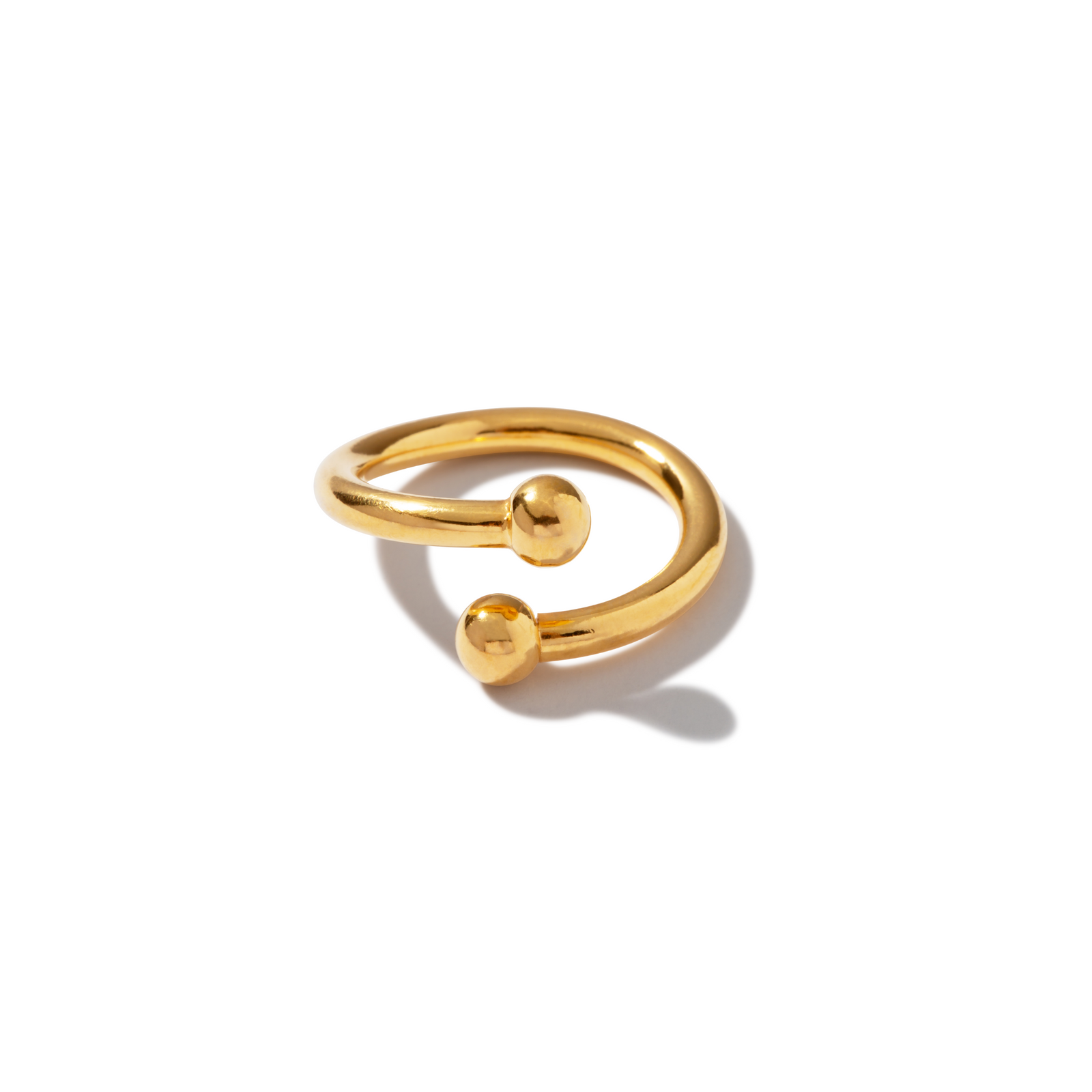The Over Easy Orbita Ring by JAREDJAMIN Jewelry Online is a minimalist 18k gold plated piece with an open design and two polished spheres. Its tarnish-proof finish enhances the smooth, modern style against a white background.