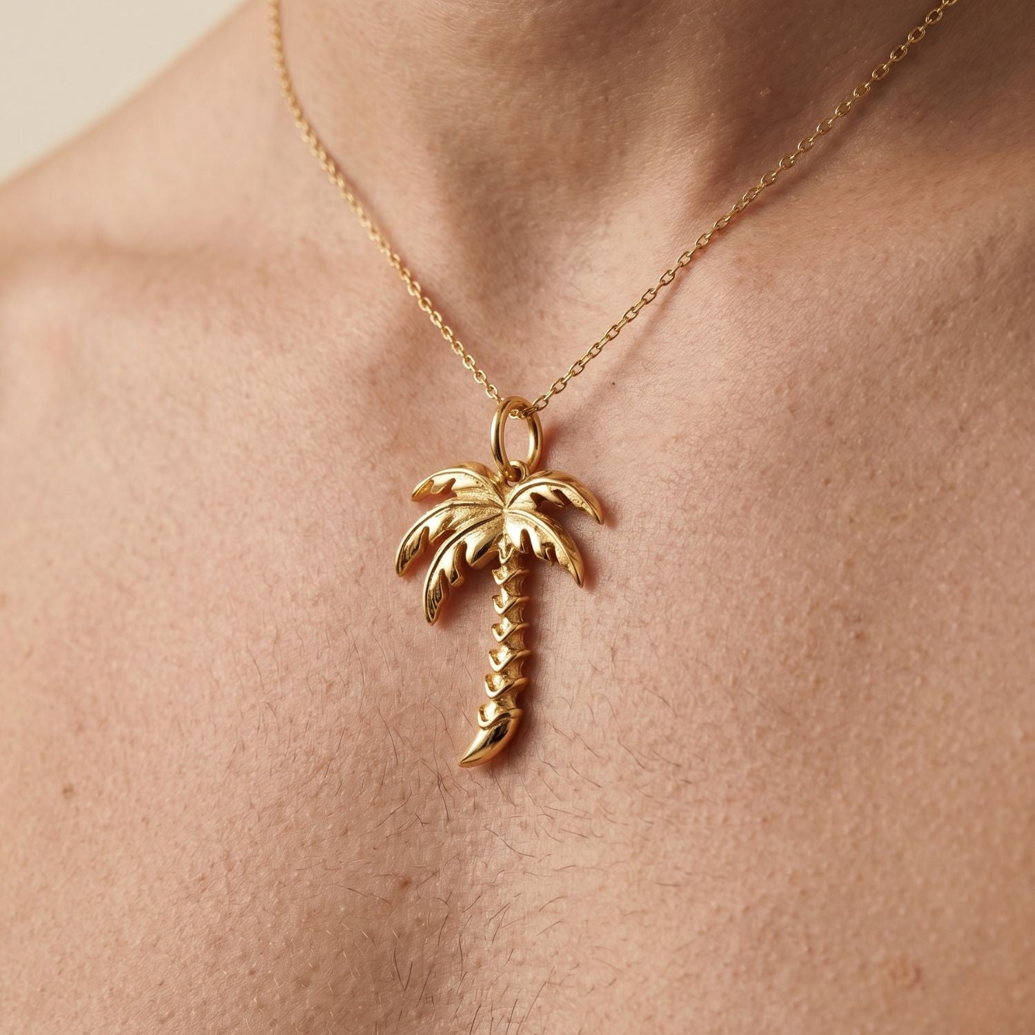 The JAREDJAMIN Jewelry Online Gold Palm Necklace Pendant Charm features textured fronds, a zigzag trunk pattern, and a top loop for chains, displayed on a plain white background.