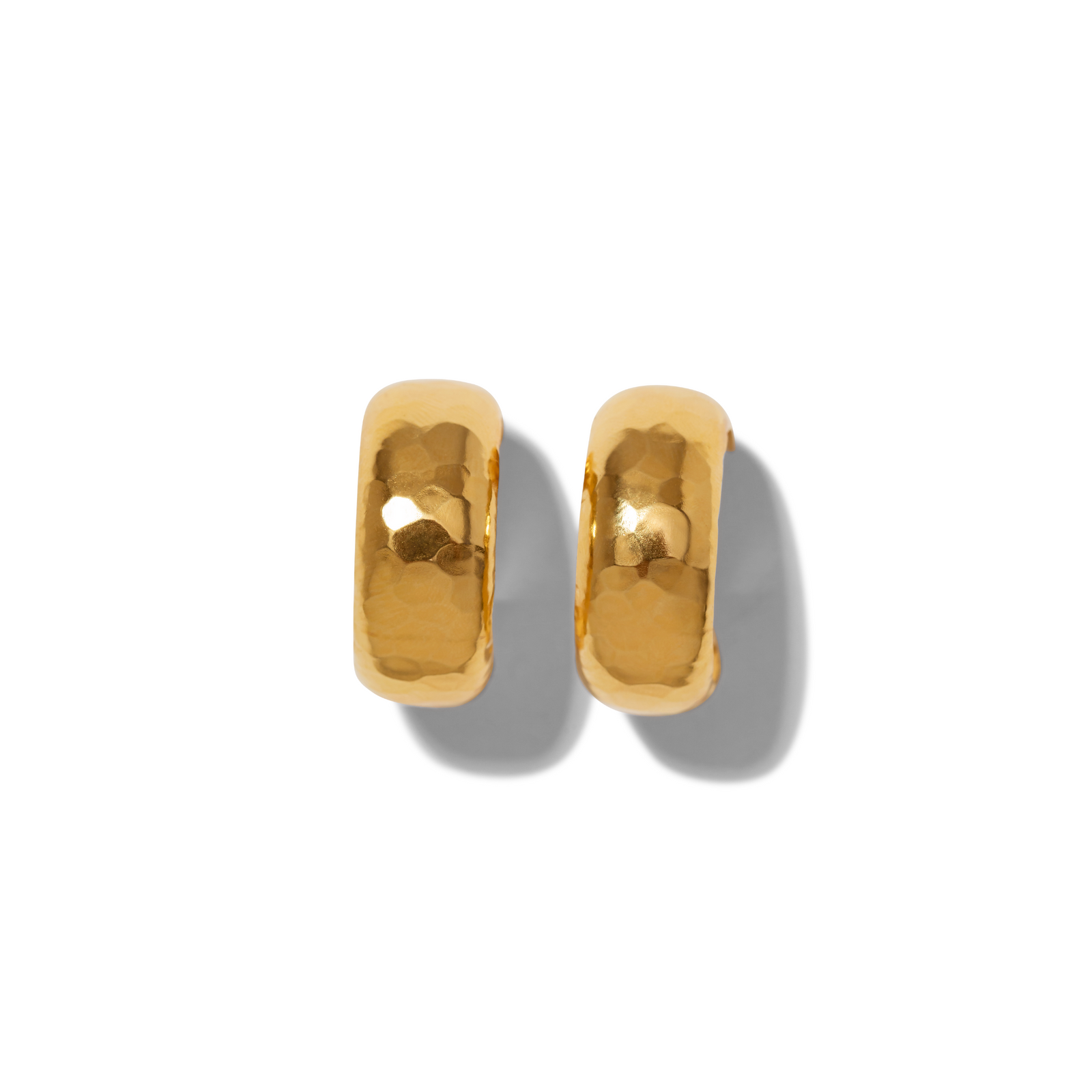 Gold Rush Hoop Earrings by JAREDJAMIN Jewelry Online: chunky 18K gold-plated hoops with a shiny hammered finish, 1 1/4" diameter, post fastenings. Shown side by side on white, casting soft grey shadows to the right.