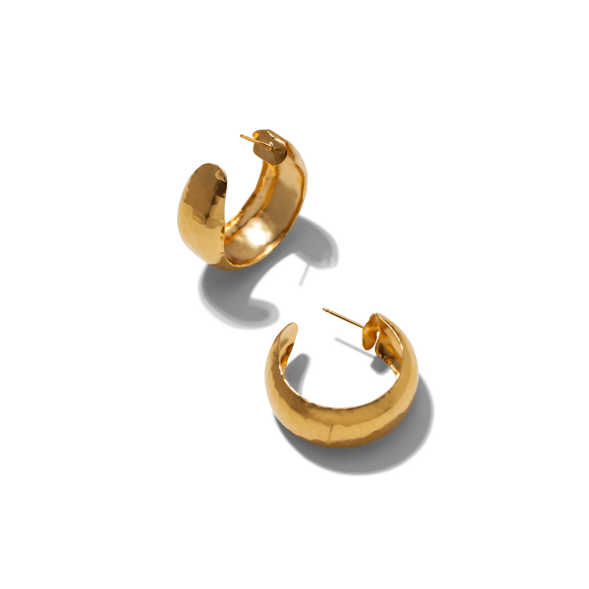 Les or Rush créole boucles d'oreilles par JAREDJAMIN Bijoux en Ligne présentent brillant, hammered 18K or plate créoles avec post fastenings. Each boucle d'oreille is slightly irregular, measures 1 1/4" in diameter, et is présenté sur a fond blanc.