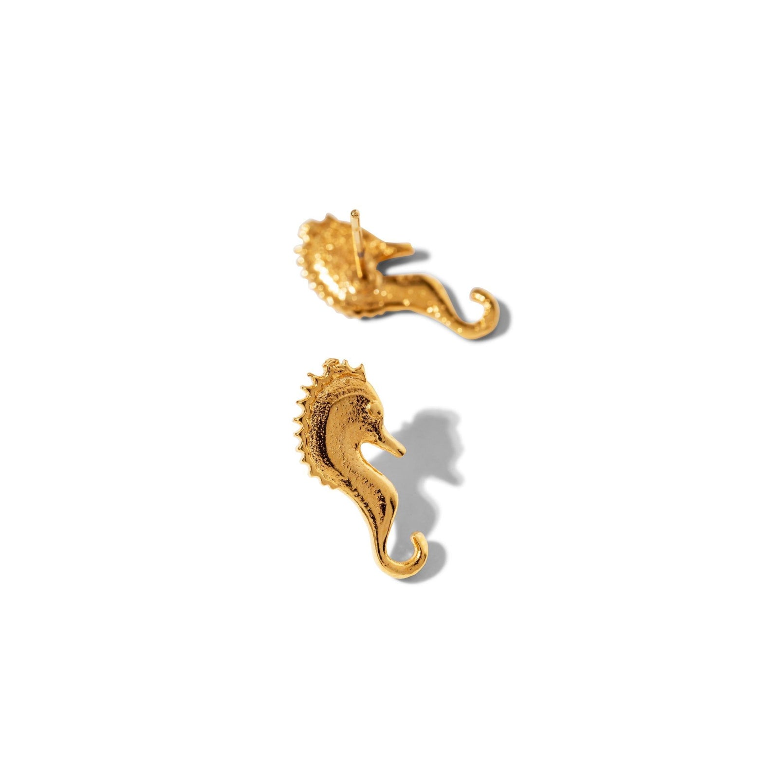 The Sea Scooter Post Earrings by JAREDJAMIN Jewelry Online are small, silver-plated seahorse studs with detailed, textured bodies and curled tails, shown facing each other on a plain white background.
