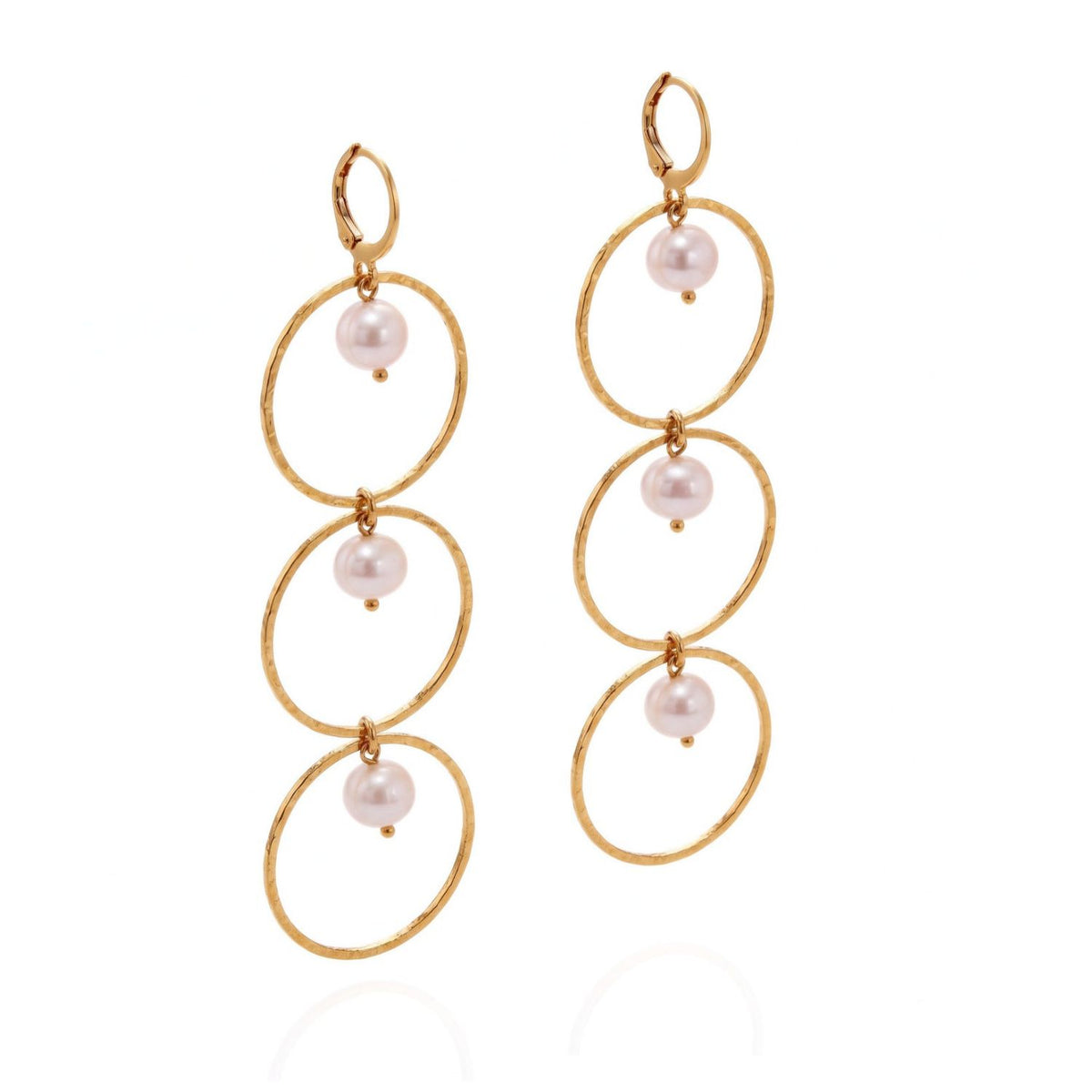 Gold dangle earrings with three stacked hammered hoops and pearl accents on each earring and leverback closures, photographed on a white background.