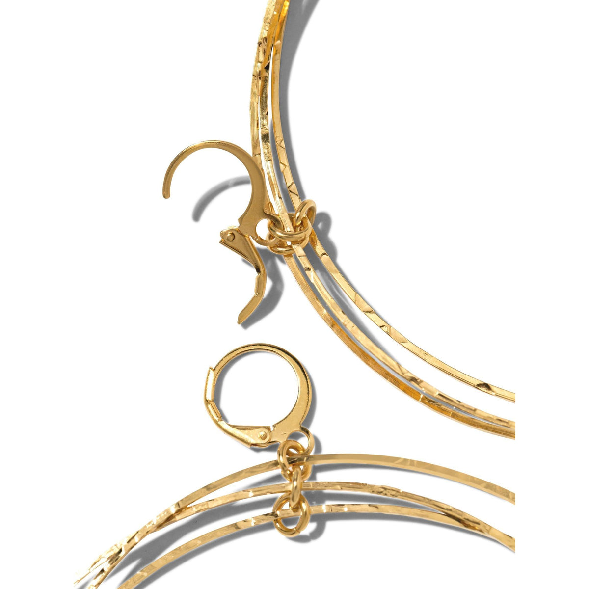 Close-up of JAREDJAMIN Jewelry Online's Gold Triple Halo Hoop Earrings: lightweight, textured hoops with hammered, overlapping bands and hinge-latch closures. Plated brass design casts unique shadows on a white background.