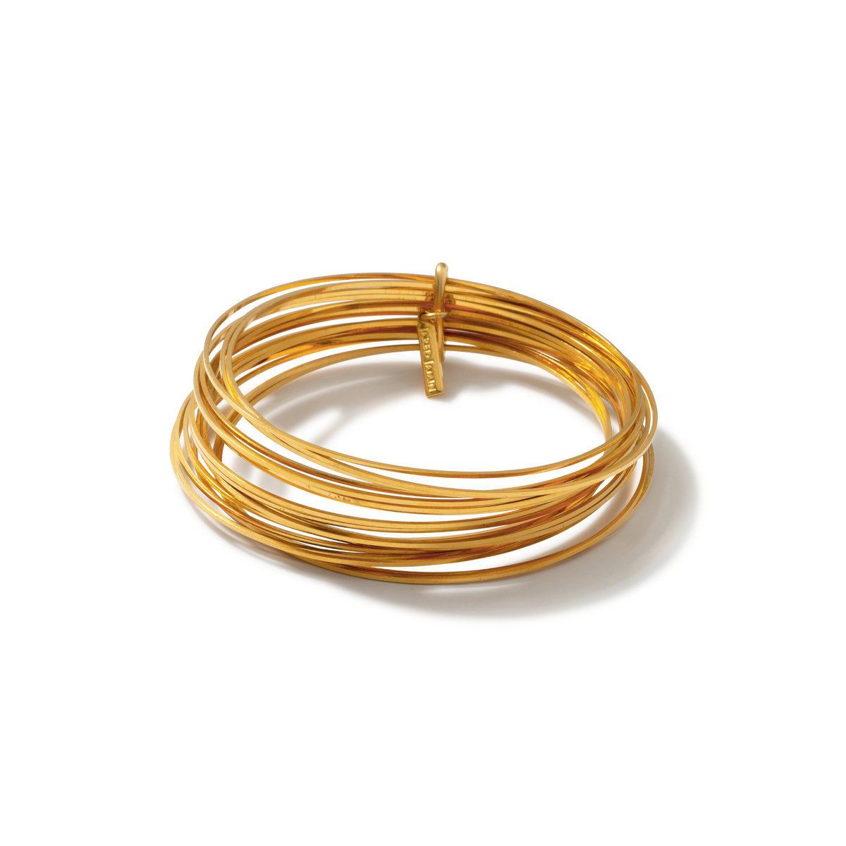 Les or Twenty Something jonc Stack par JAREDJAMIN Bijoux en Ligne features slender, brillant 18K plaqué or joncs avec a small engraved or tag, elegantly stacked et casting a soft shadow sur un fond blanc.