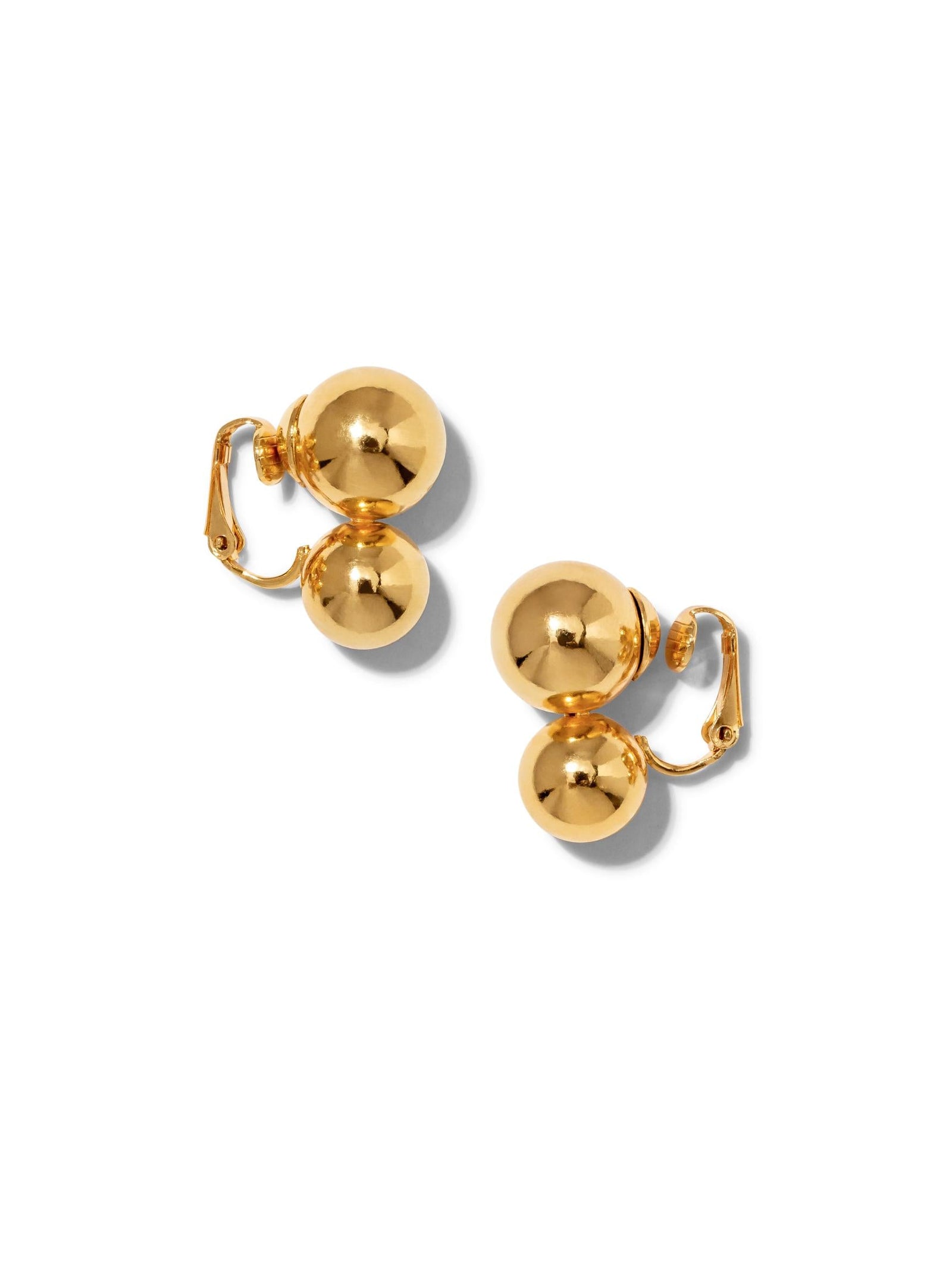 A pair of Gold Uptown Orbita Clip On Earrings by JAREDJAMIN Jewelry Online, each with two polished 18K gold-plated spheres of varying sizes linked together, shown on a white background with visible clip mechanisms.